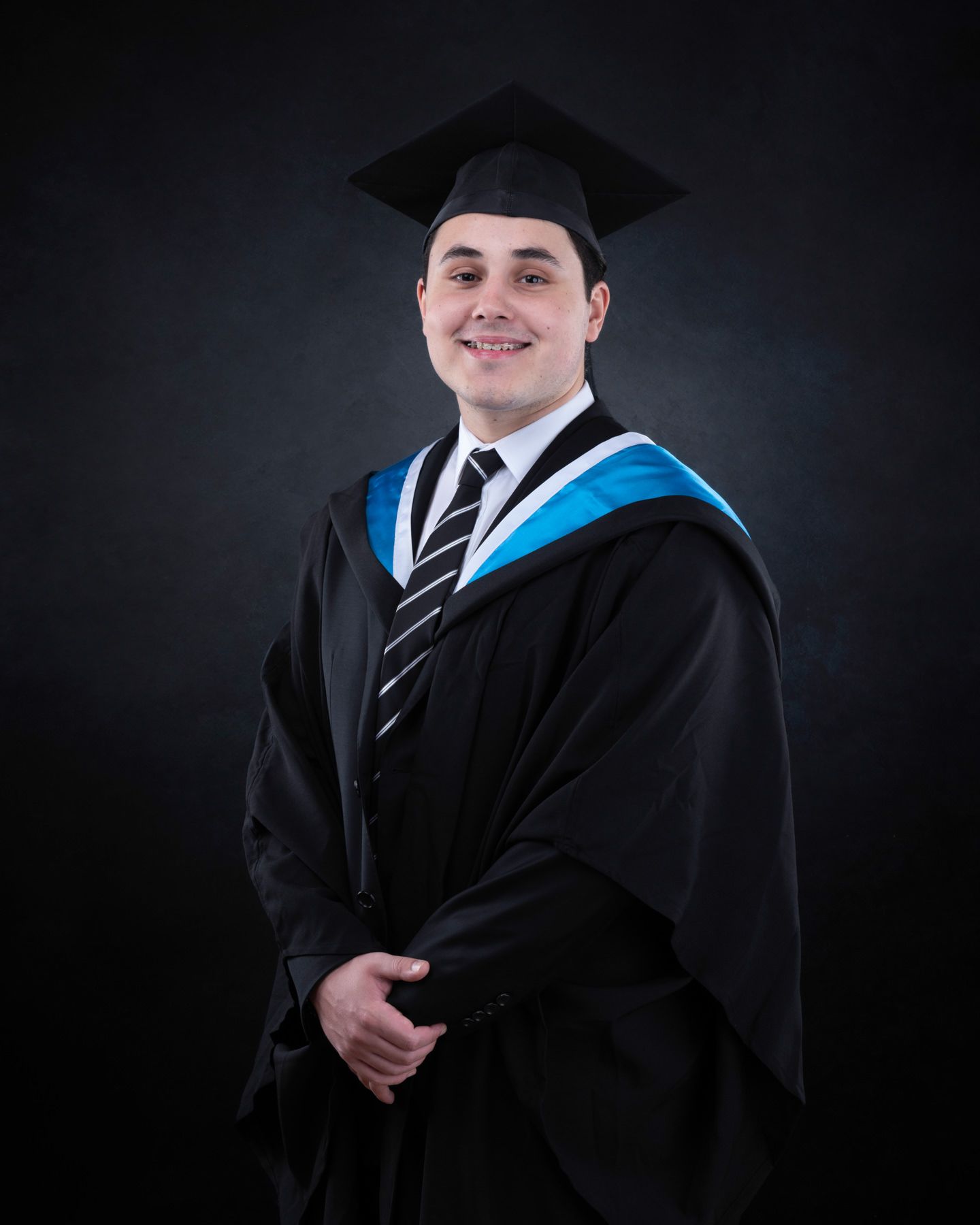 A series of graduation portraits showing a graduate in traditional black cap and gown with blue stole against dark background.