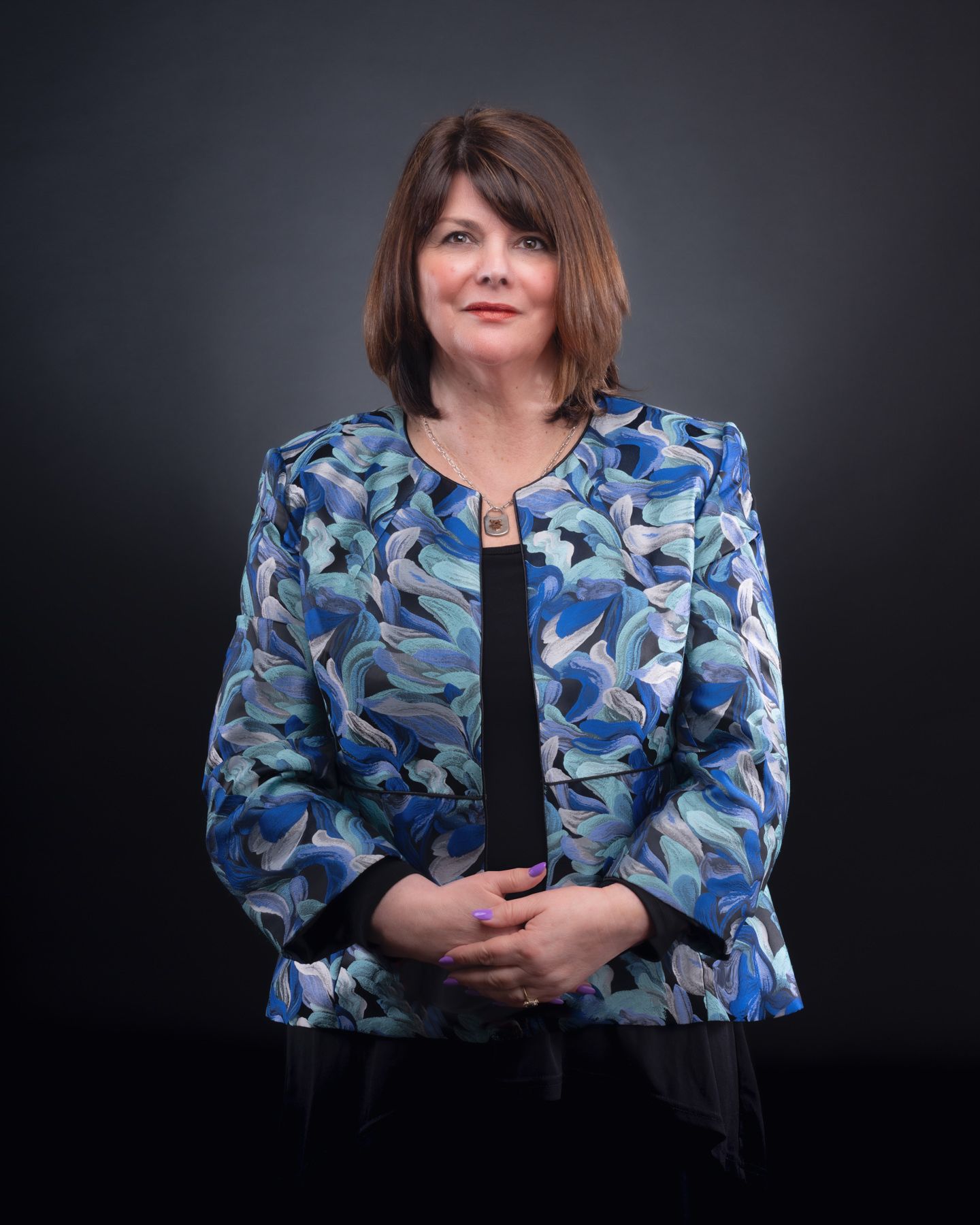 Professional portrait series in blue floral print blouse against dark background showing different poses and angles.