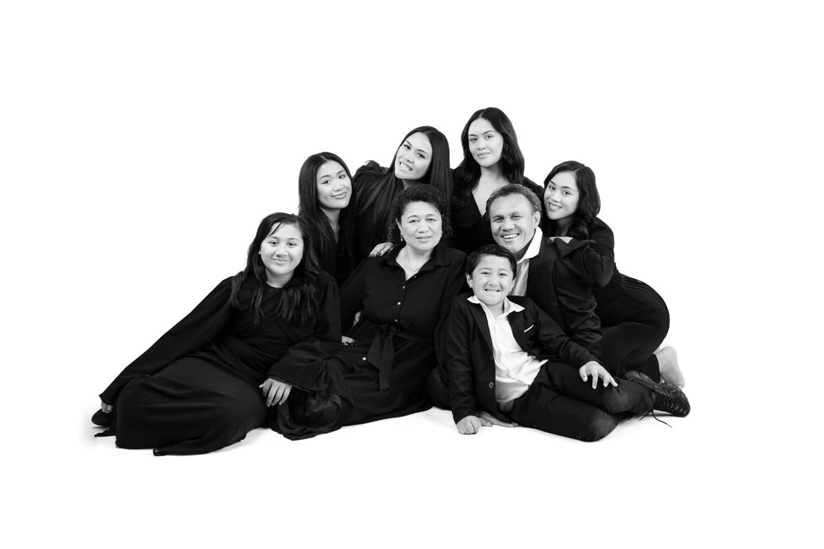 A sequence of black and white photos showing people in dark clothing posing together in different playful arrangements.