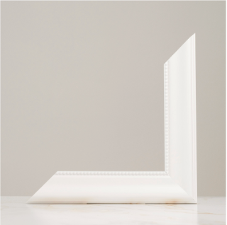 White picture frame corner piece displayed against a neutral gray background on a white surface.
