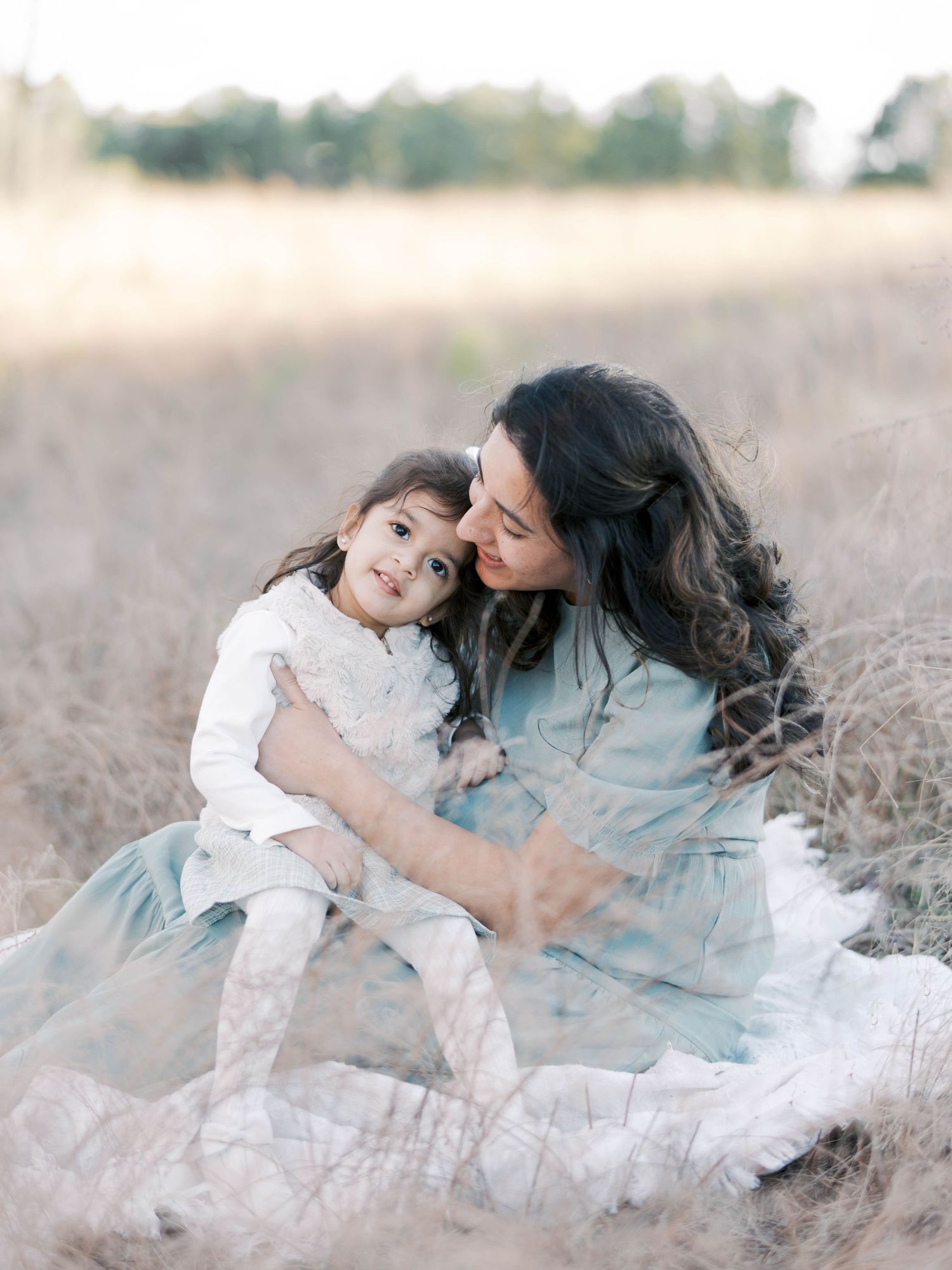 Sweet moment shared in a dreamy field with soft natural lighting.