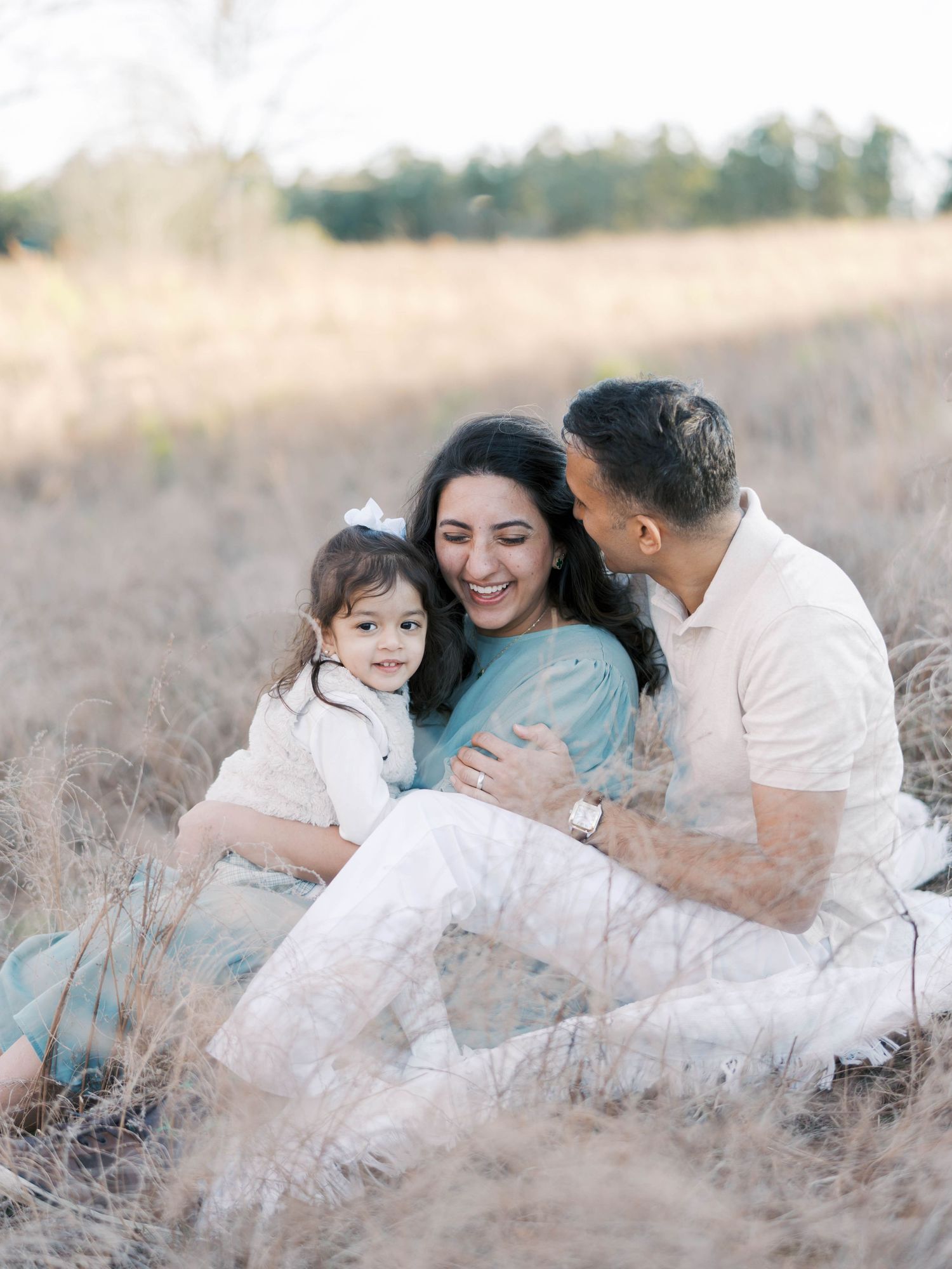 Candid family portrait in a rustic field during golden hour.