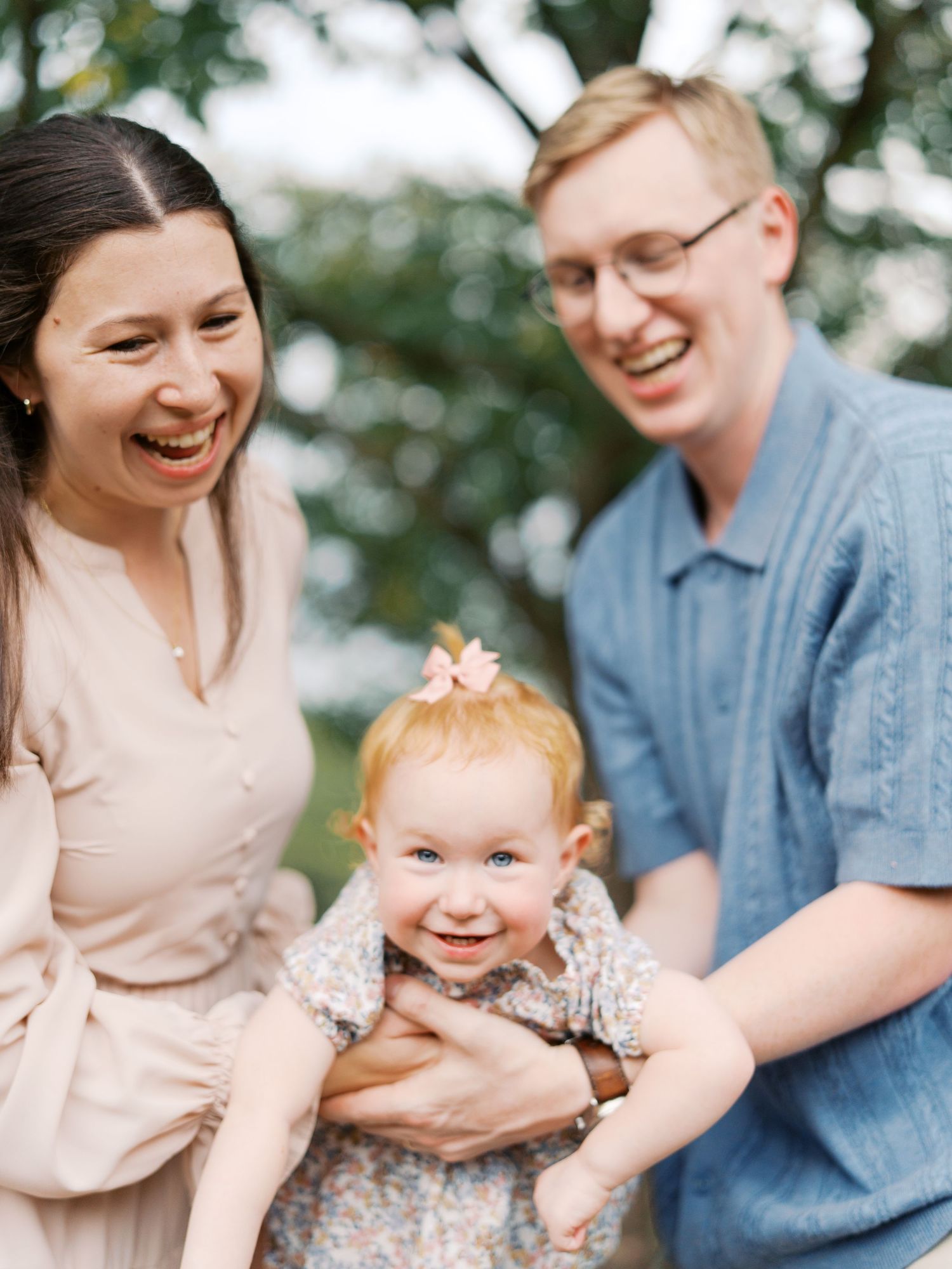 A family shares joyful moments together while sitting outdoors in casual attire.