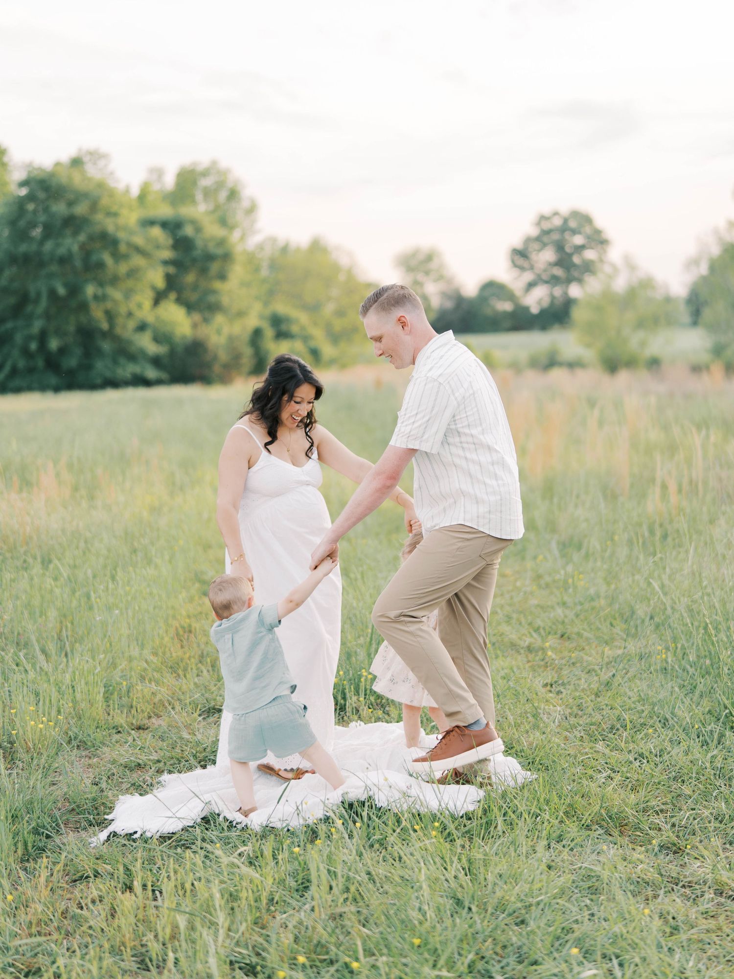 Couple holding hands and dancing together in a summer meadow.