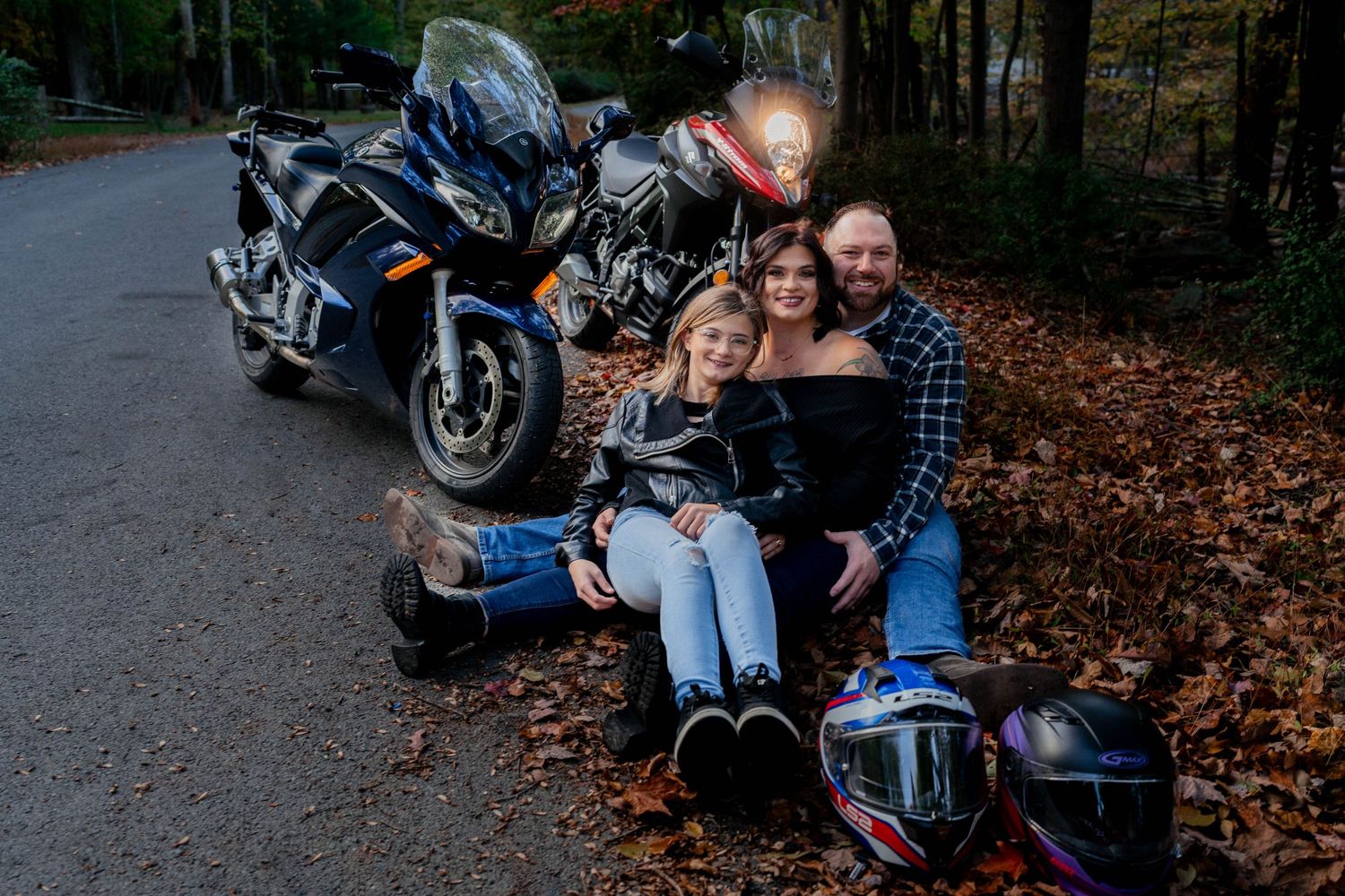 Family motorcycle photoshoot in autumn – candid outdoor portrait with two bikes, fall leaves, and helmets. Adventure & love captured