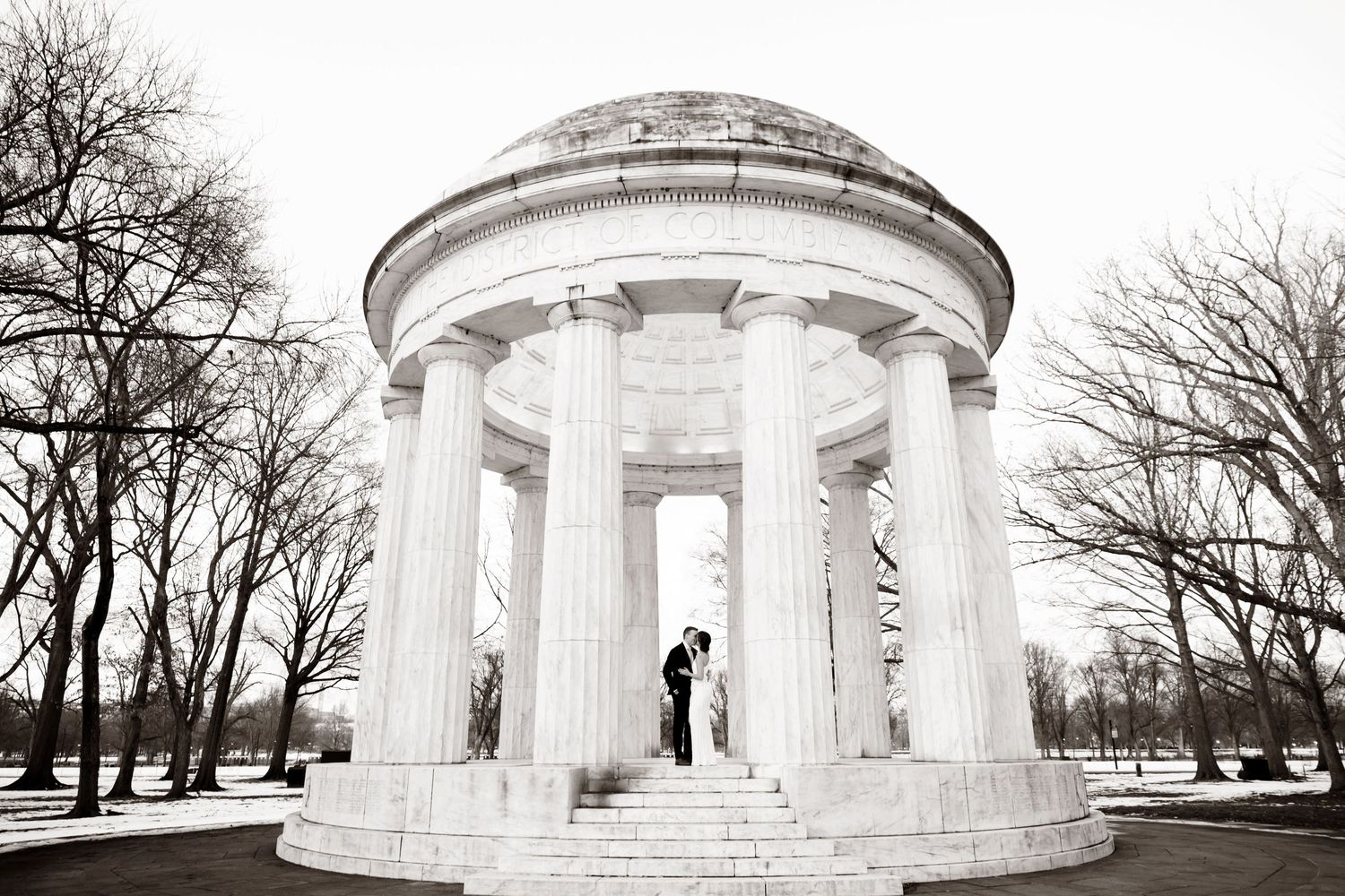 A silhouetted figure stands inside a classical white marble rotunda with columns.