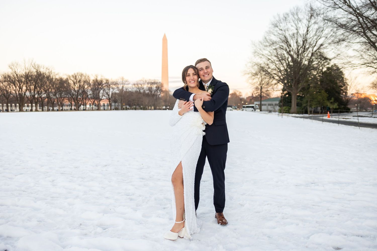 A romantic winter photo shoot with the Washington Monument visible in the snowy background.