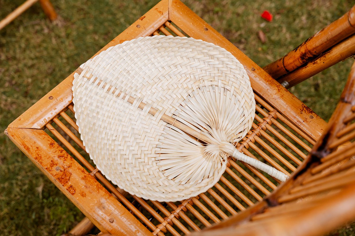 Traditional bamboo hat weaving tools and materials arranged on a wooden surface with natural fibers.