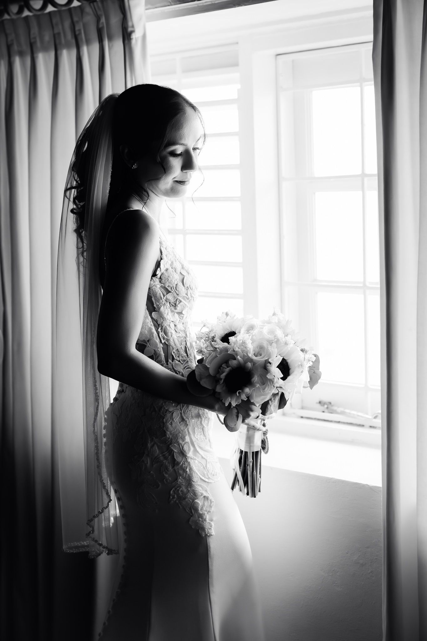 Black and white triptych of a bride in lace dress holding bouquet while standing near window with soft light.