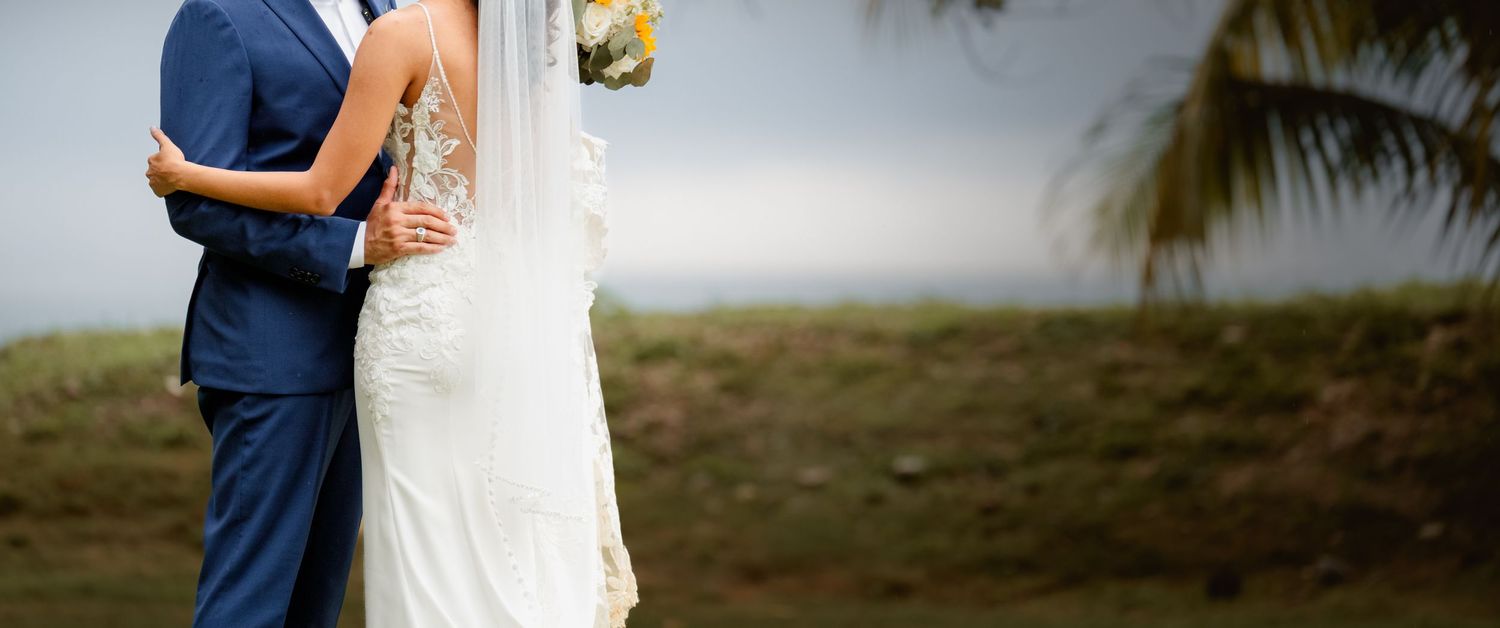 Two elegantly dressed people hold each other close during a romantic outdoor photo session at sunset in nature.