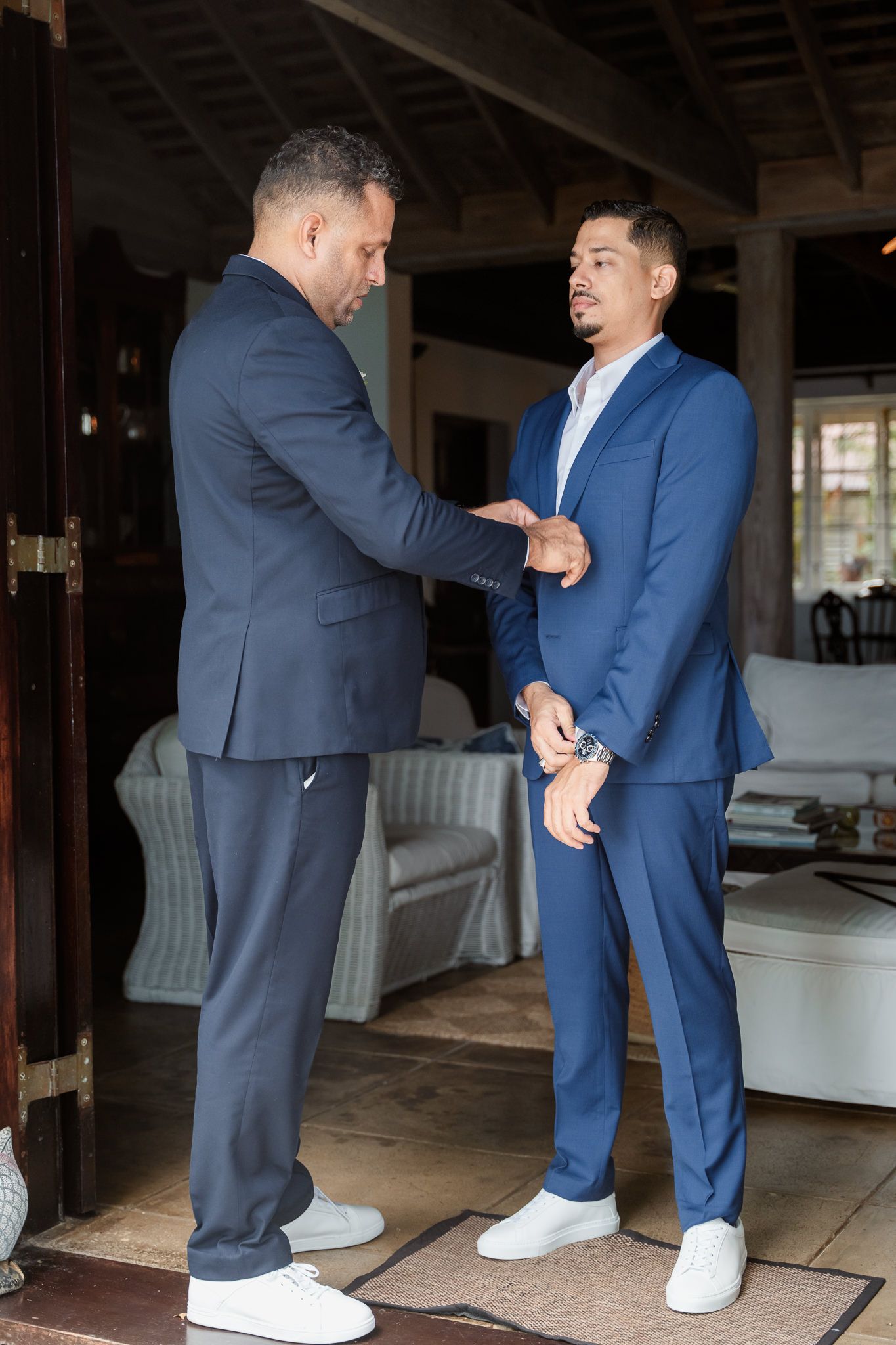 Sequence showing two people in contrasting navy and blue suits comparing their white sneakers.