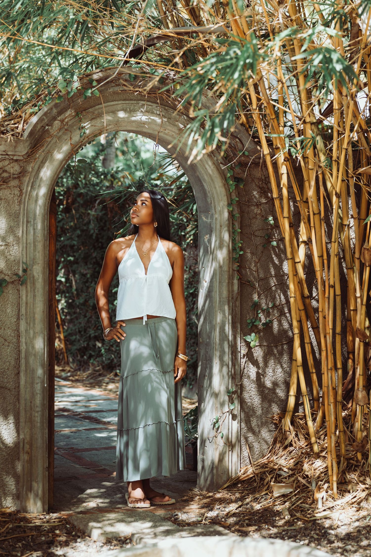 A series of photos showing a stone archway surrounded by bamboo trees creating a tranquil garden pathway.