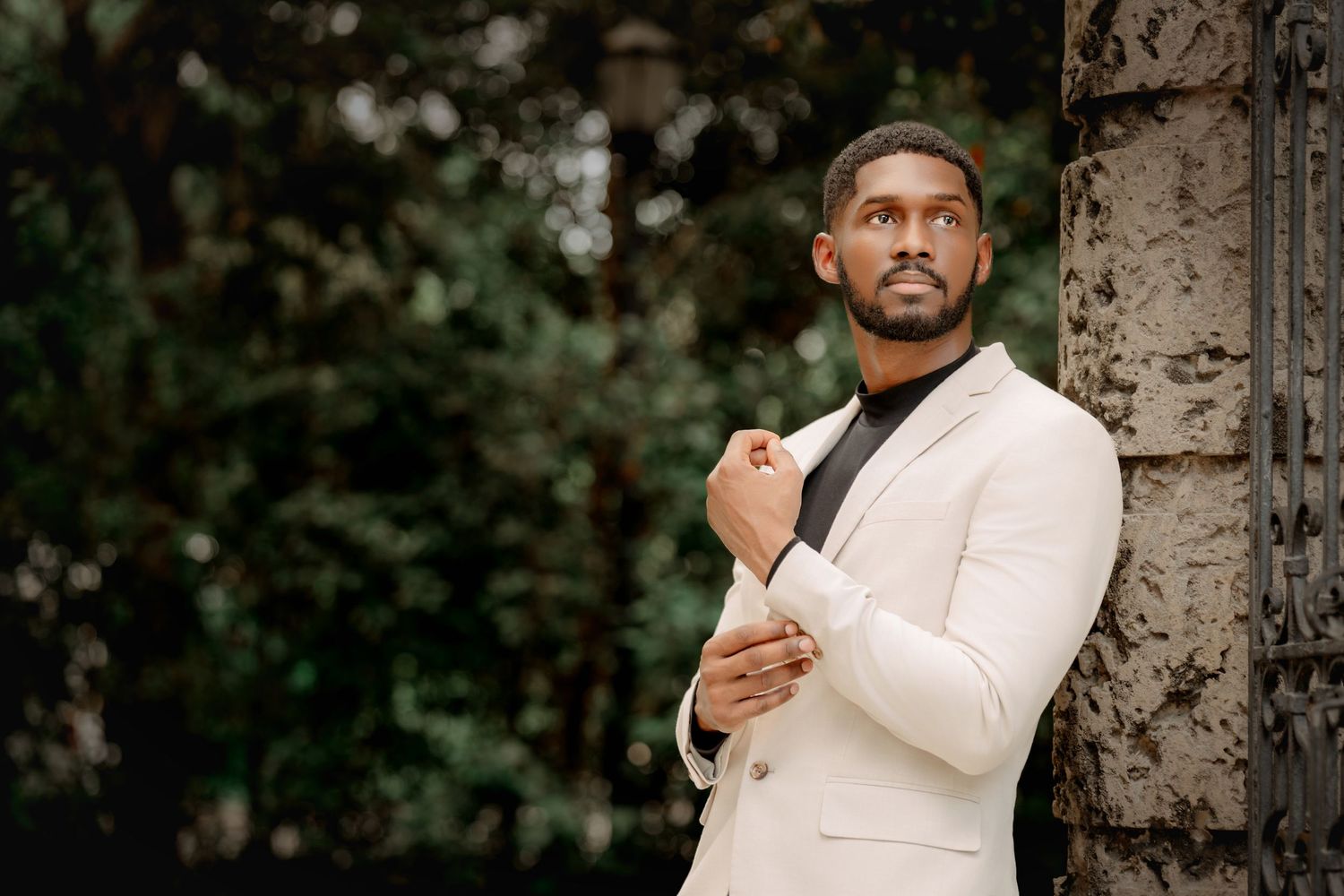 Person in white traditional attire poses against a tree in a series of candid outdoor shots.