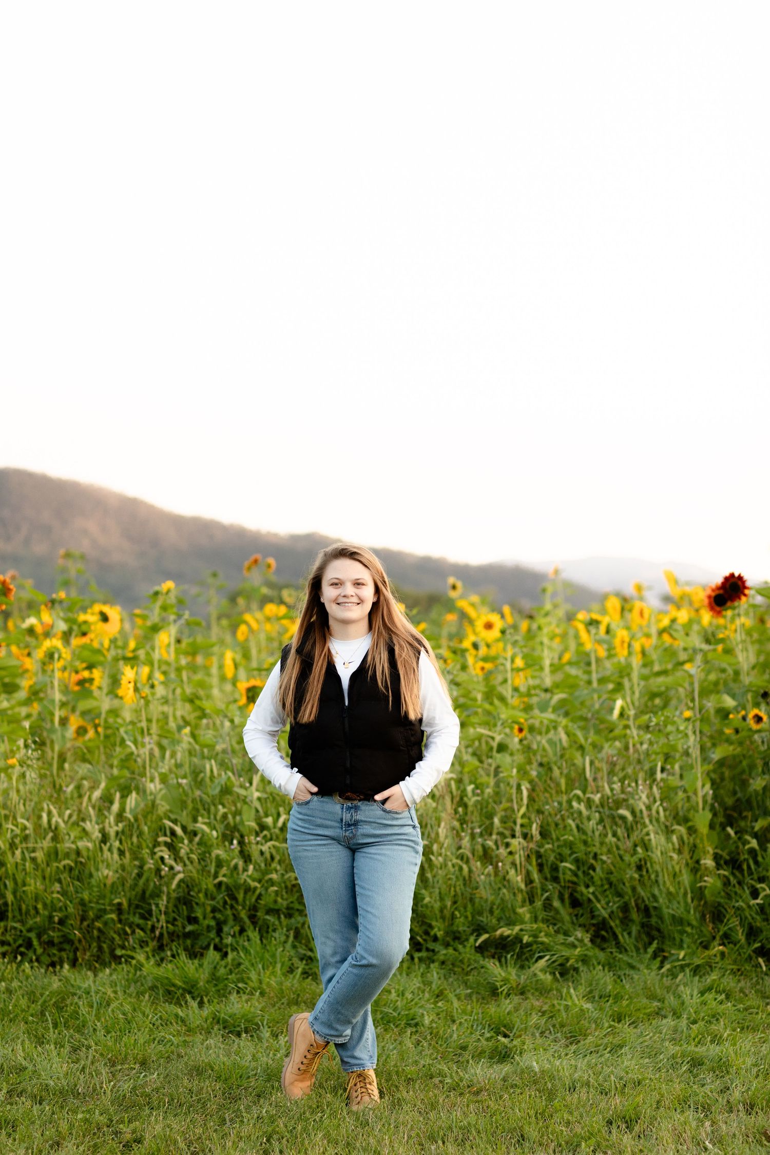 A joyful outdoor photoshoot in a field of blooming sunflowers at sunset.