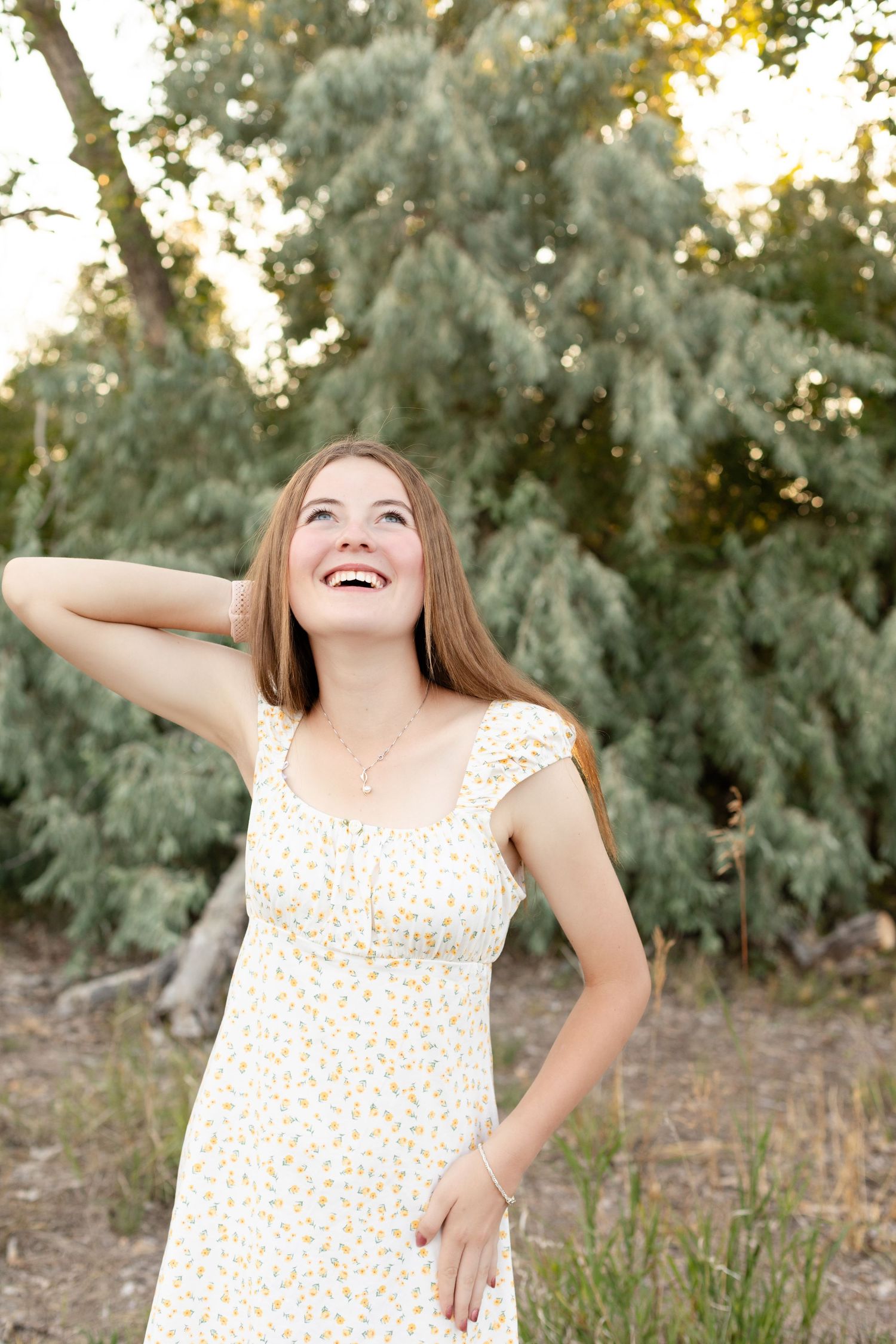 Candid laughing moments captured outdoors against a backdrop of silver-leafed trees.