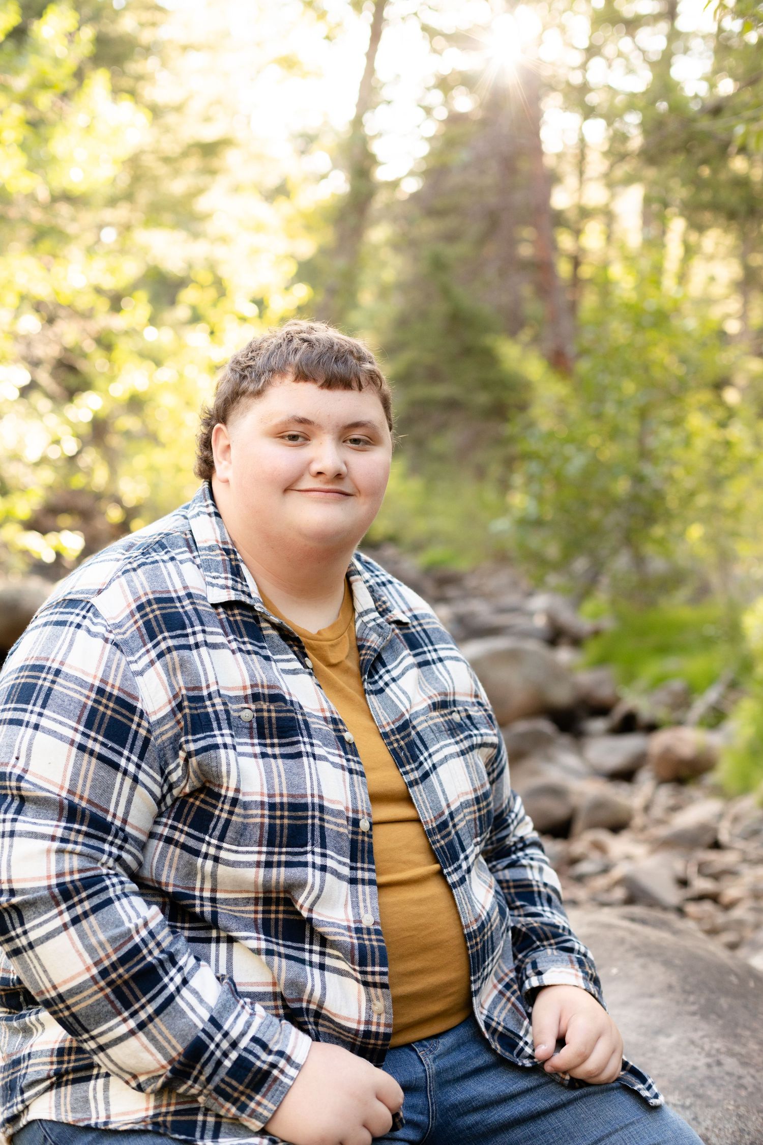 A series of casual portraits taken in a wooded area with rocks and pine trees in the background.
