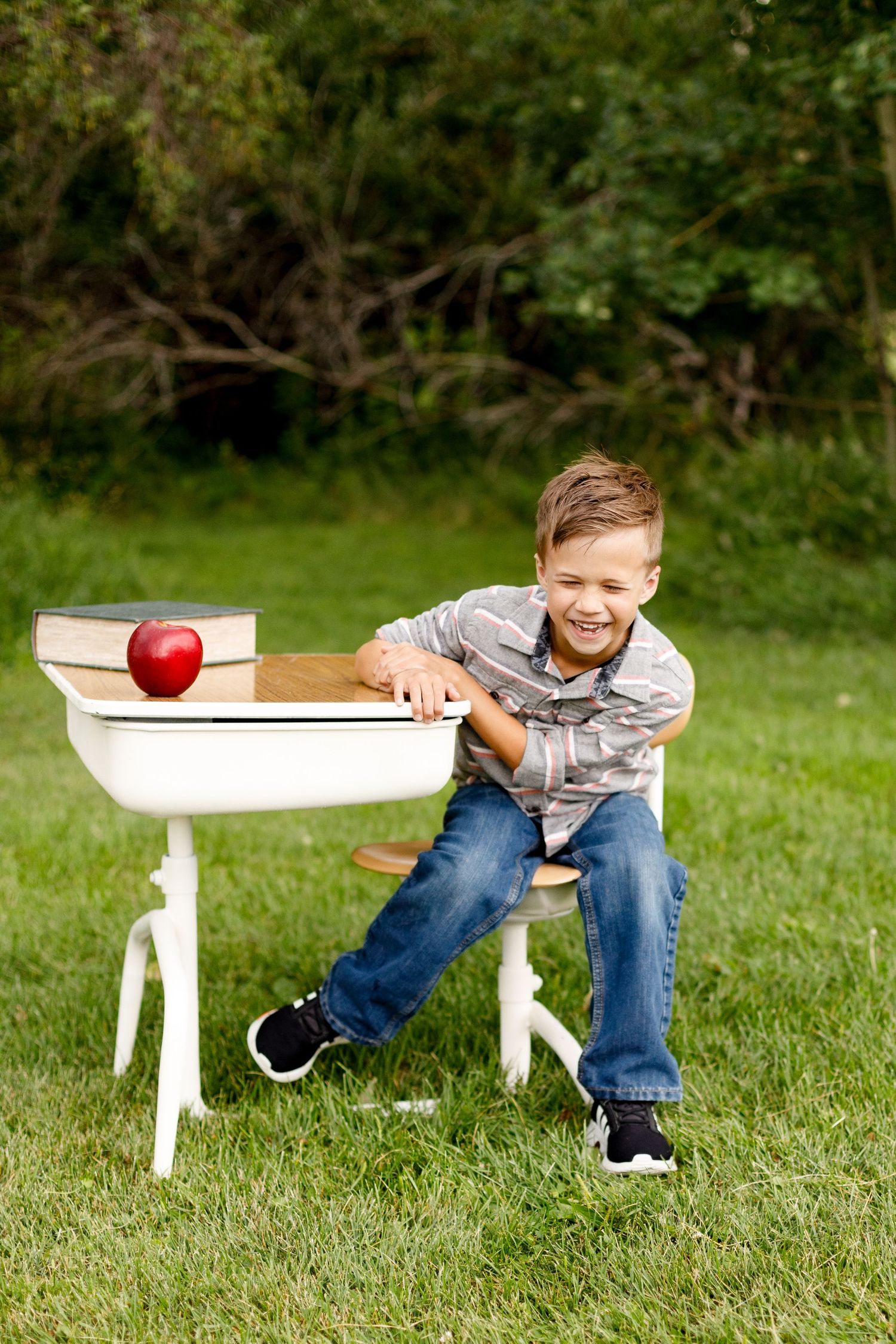 A sequence showing an apple rolling off a small white bench on grass in an outdoor setting.