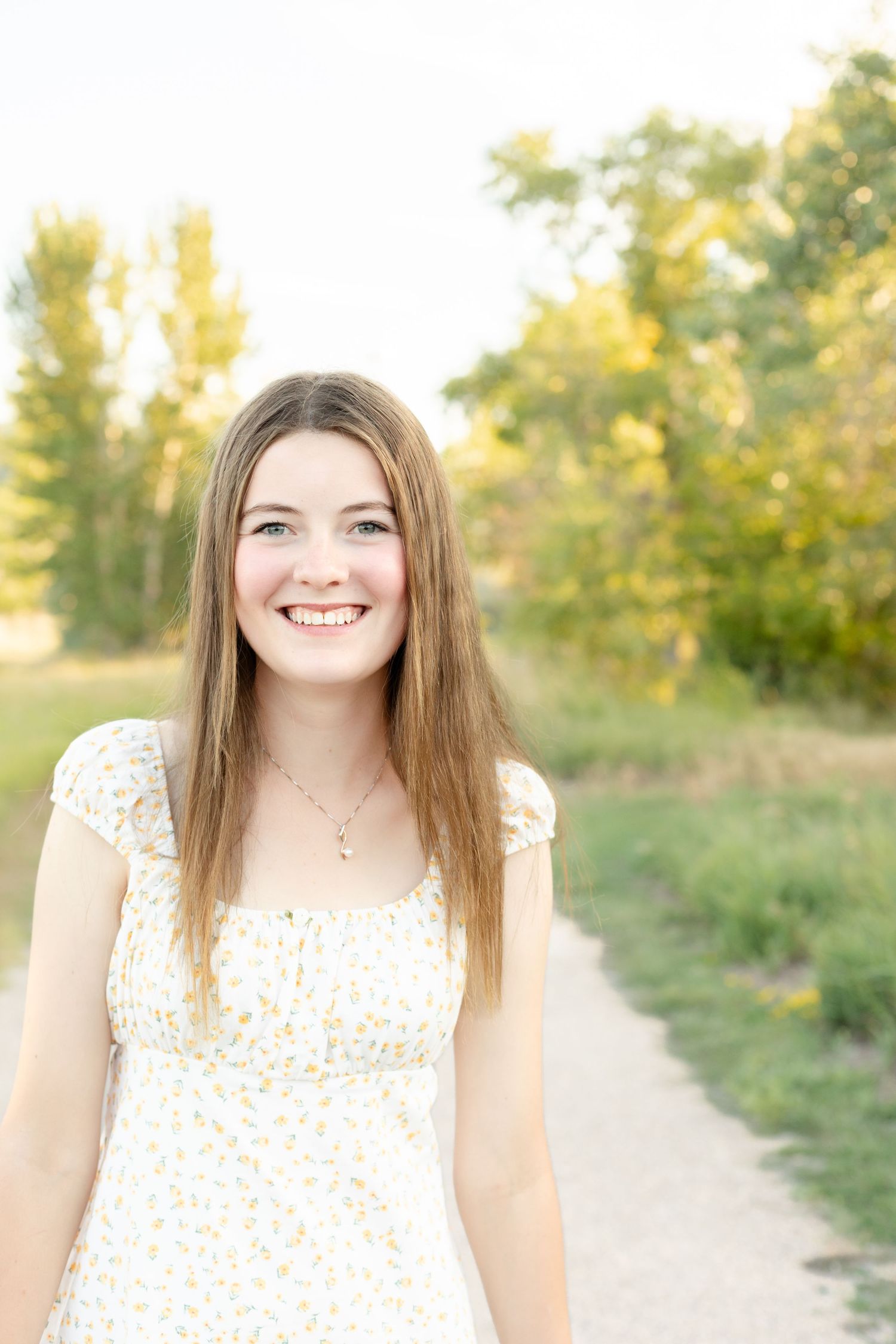 Natural light portraits captured on a dirt path with soft summer evening lighting and greenery.