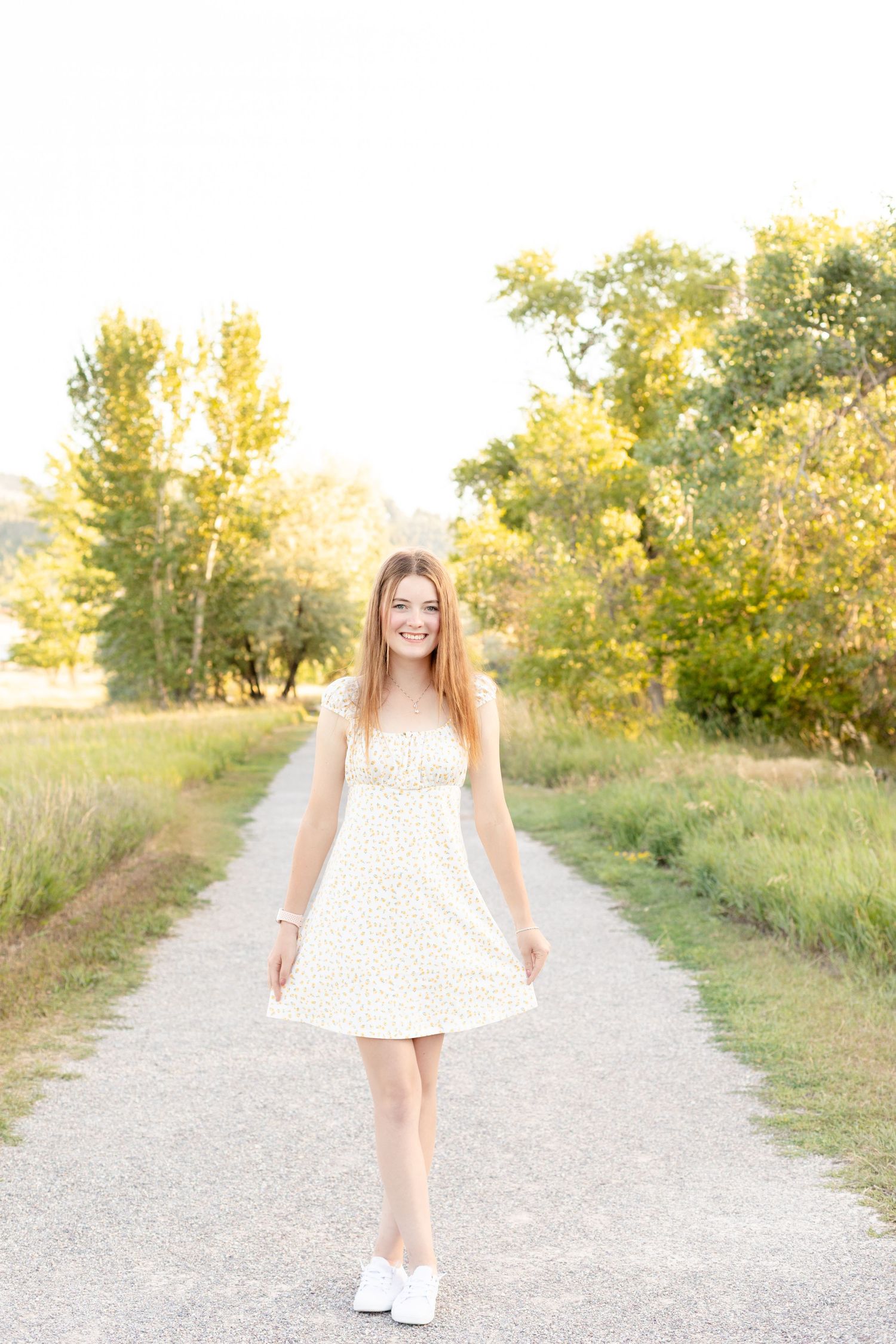 A sequence of shots showing someone in a white dress walking along a sunlit gravel path.