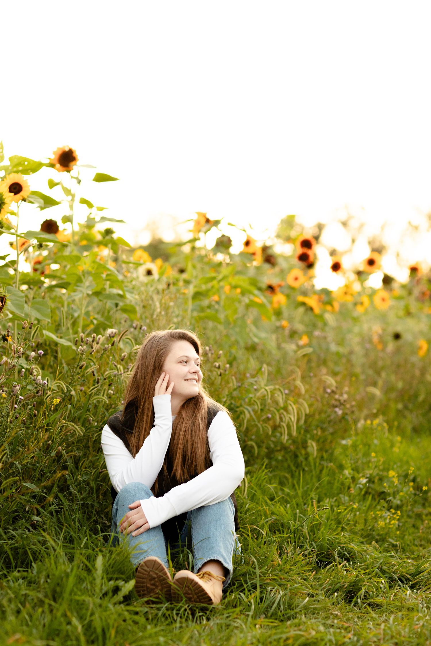 Casual outdoor portraits taken in a sunflower field during golden hour lighting.