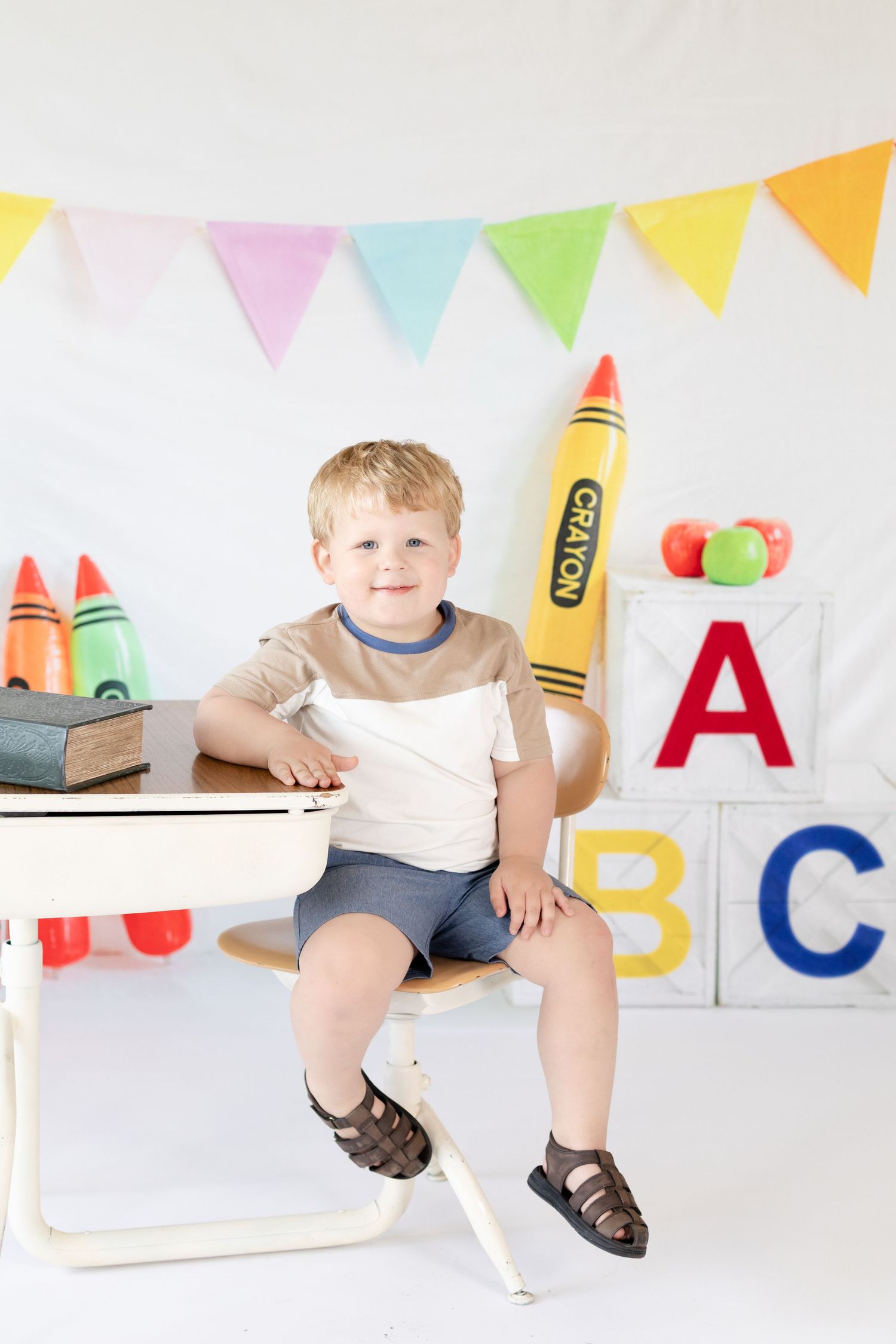 Colorful alphabet letters and party bunting decorate a bright white playroom setting with educational elements.