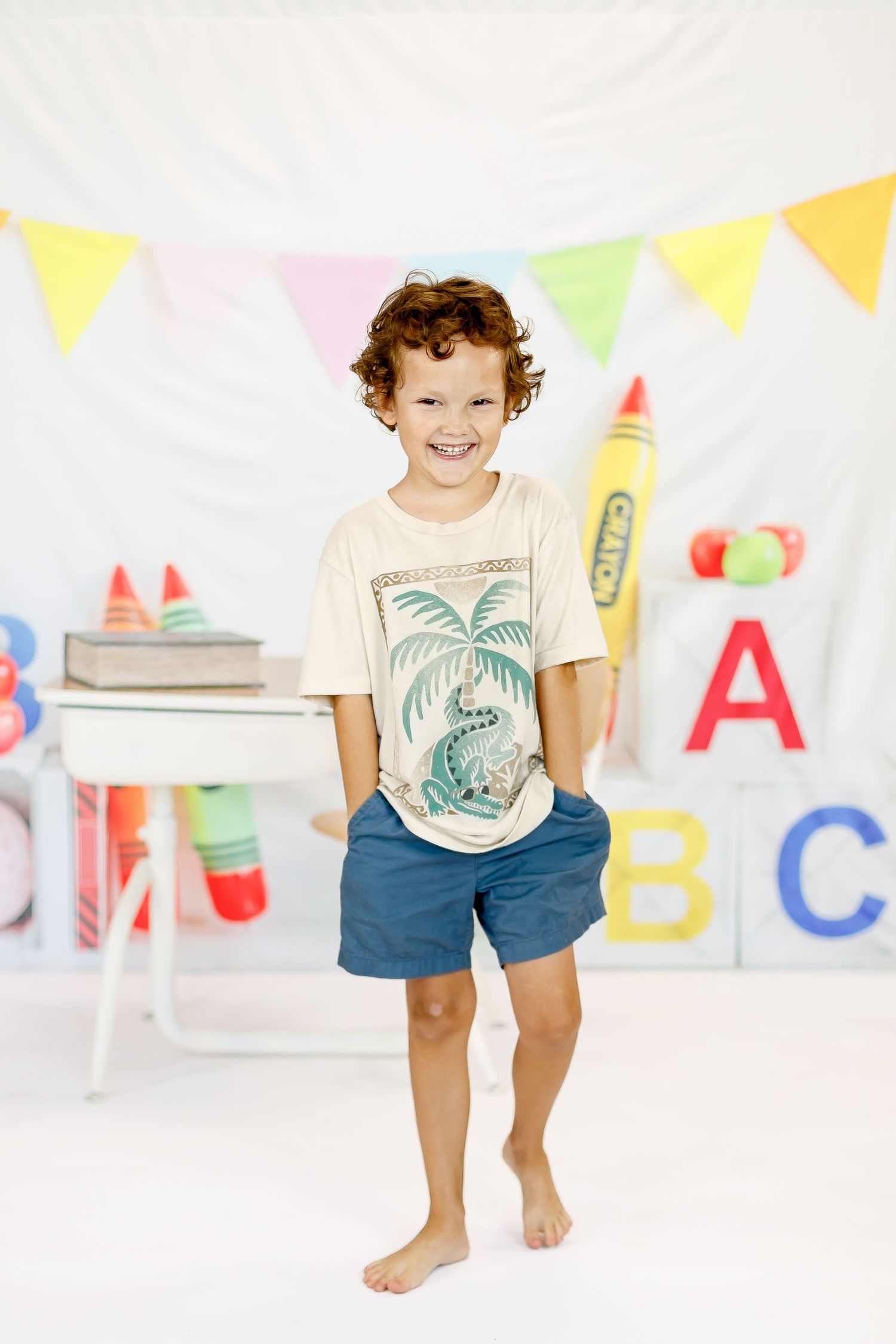 Fun and colorful playroom decorated with letter blocks, rainbow bunting, and educational toys creates a cheerful setting.