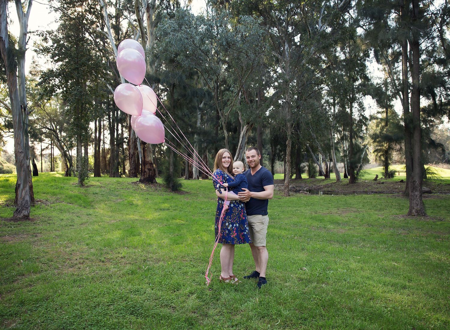 Gender reveal pregnant photoshoot with pink balloons. It's a girl.