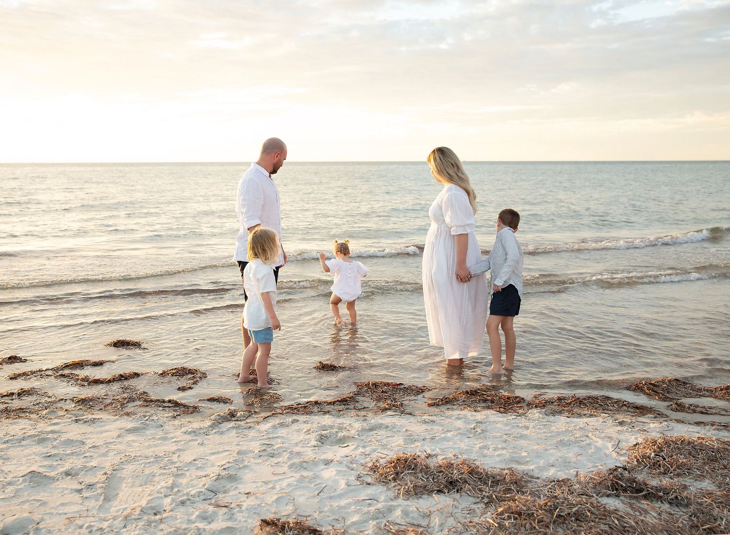 Toddler splashing in waves, documentary style family photography. Largs Bay Beach, Adelaide.