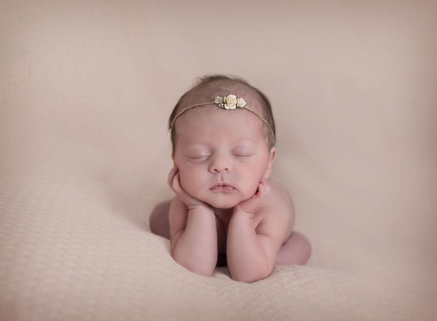 Newborn baby girl in froggy pose during newborn photoshoot.