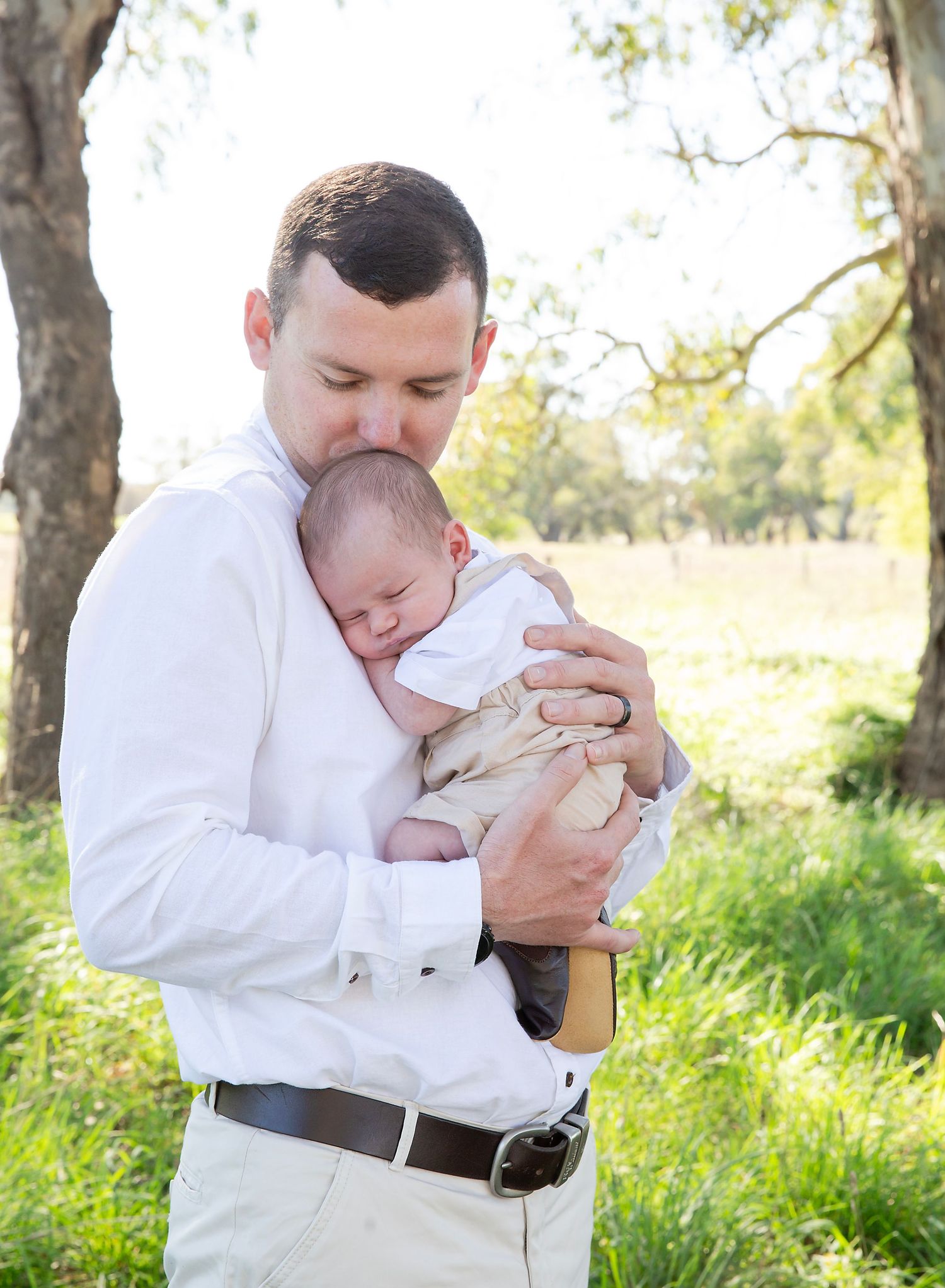 A proud dad with his adorable sleeping newborn baby, in outdoor newborn session in Mt Barker Adelaide SA.
