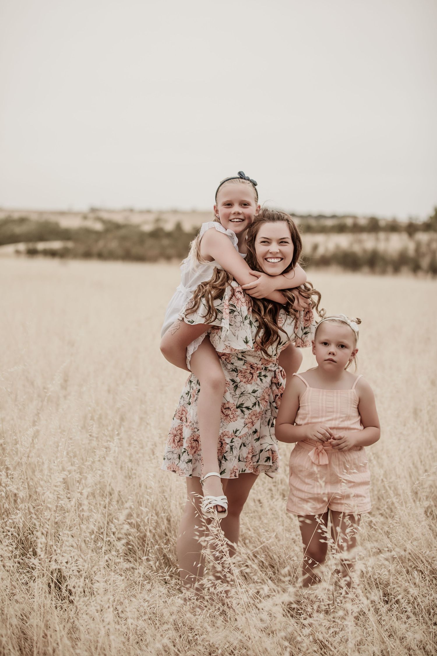 Chloe White the photographer with her two children in a field.