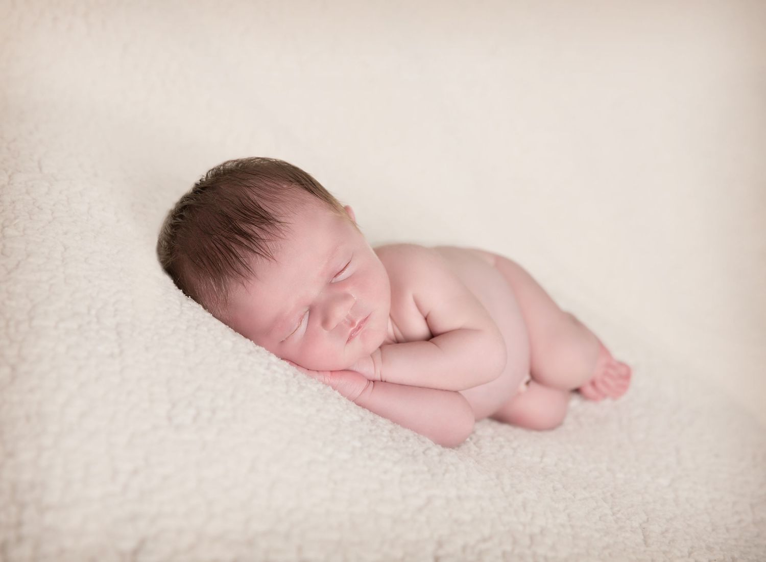 Newborn baby boy, sleeping in sidling pose, hands under cheek. In-home newborn photoshoot in Adelaide SA.