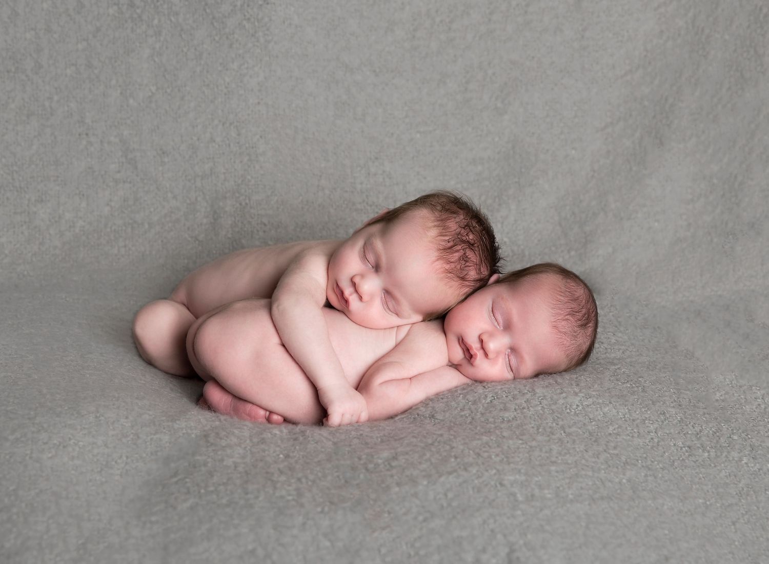 Twin brothers cuddled up together, super cute newborn poses for twins in newborn photography. In-home newborn photoshoot in Adelaide SA.