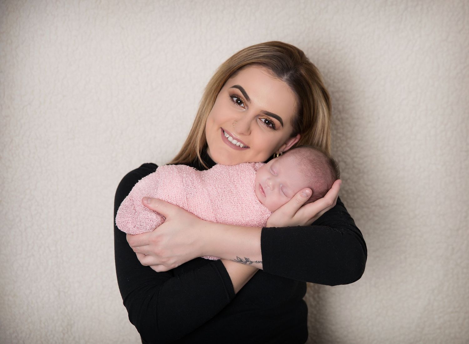 A new mum with her newborn baby sleeping cradled in her arms. In-home newborn photoshoot in Adelaide SA.
