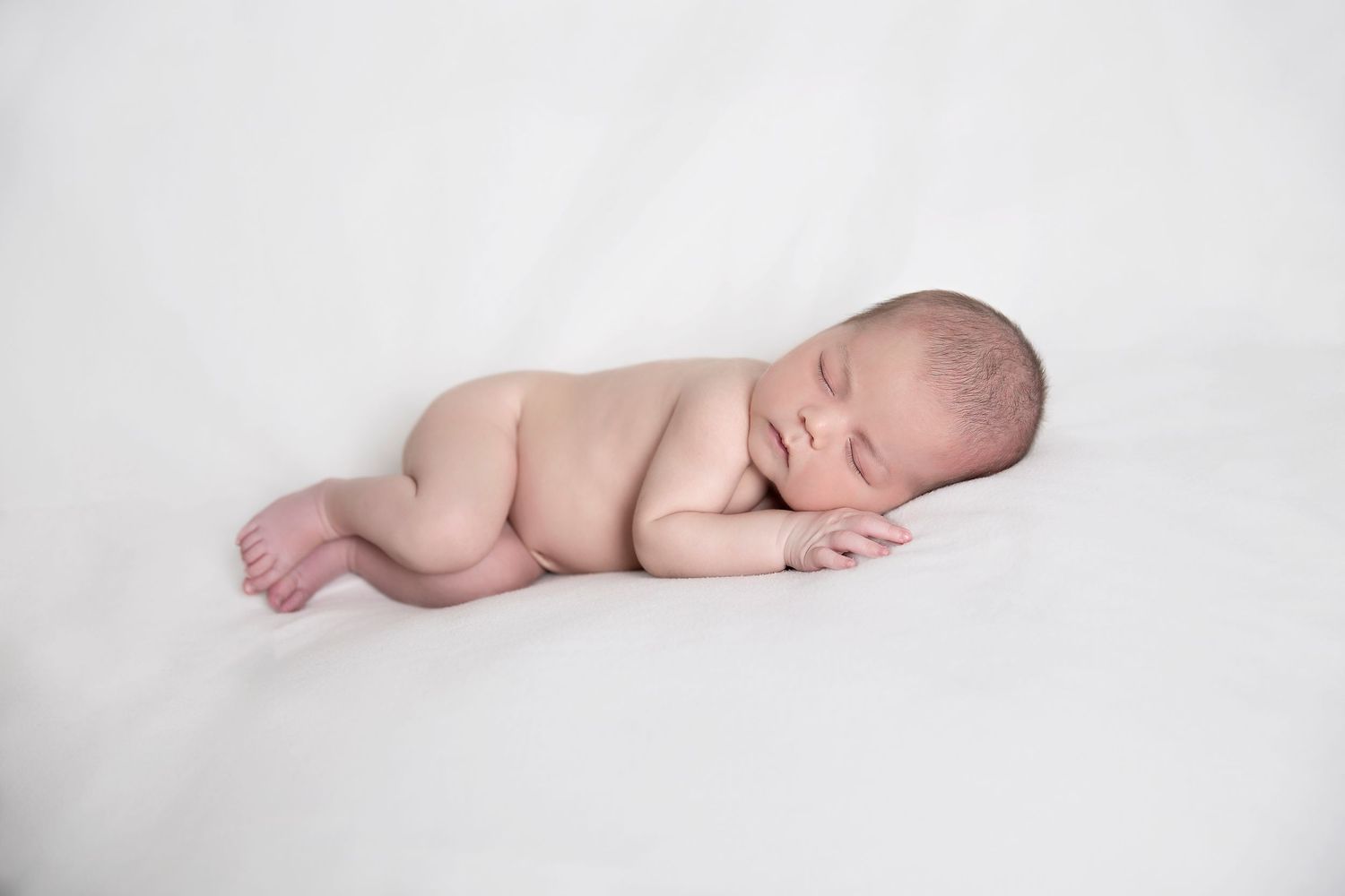 Newborn boy posed in a basket with knitted blanket during Adelaide studio session