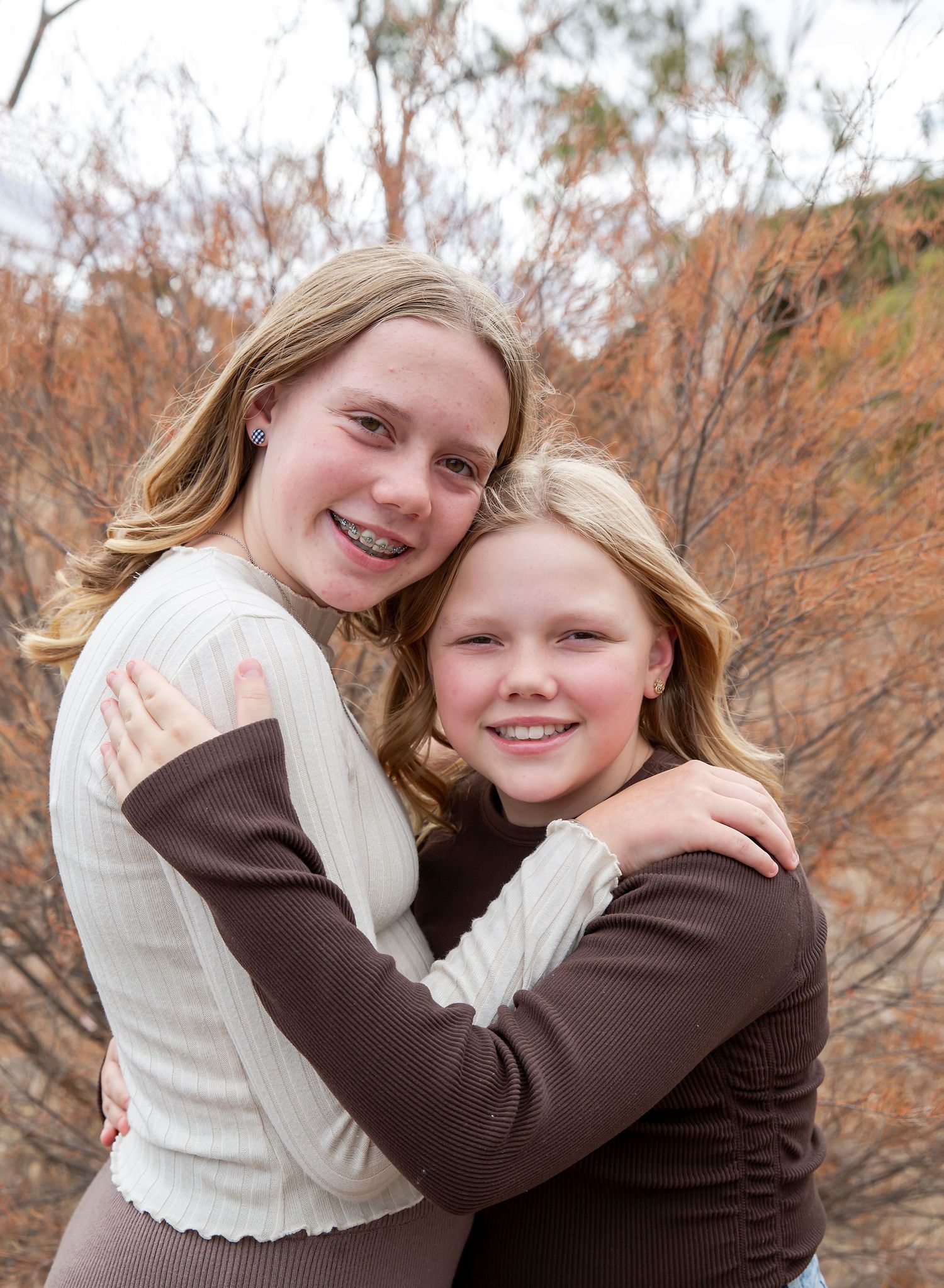 Two sisters smiling in a loving embrace in family photoshoot in reserve in Virginia SA.