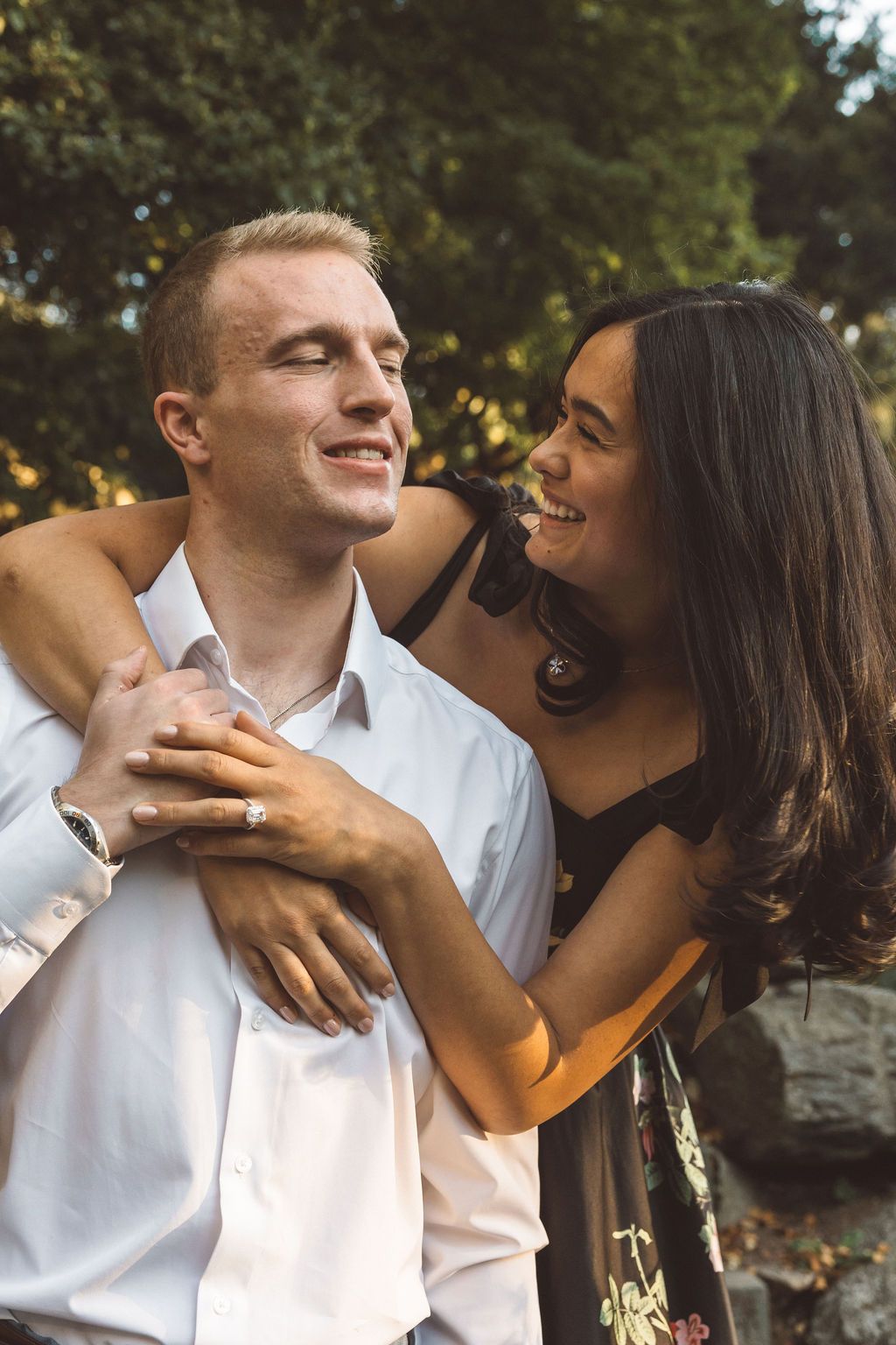 newly engaged couple smiling at each other