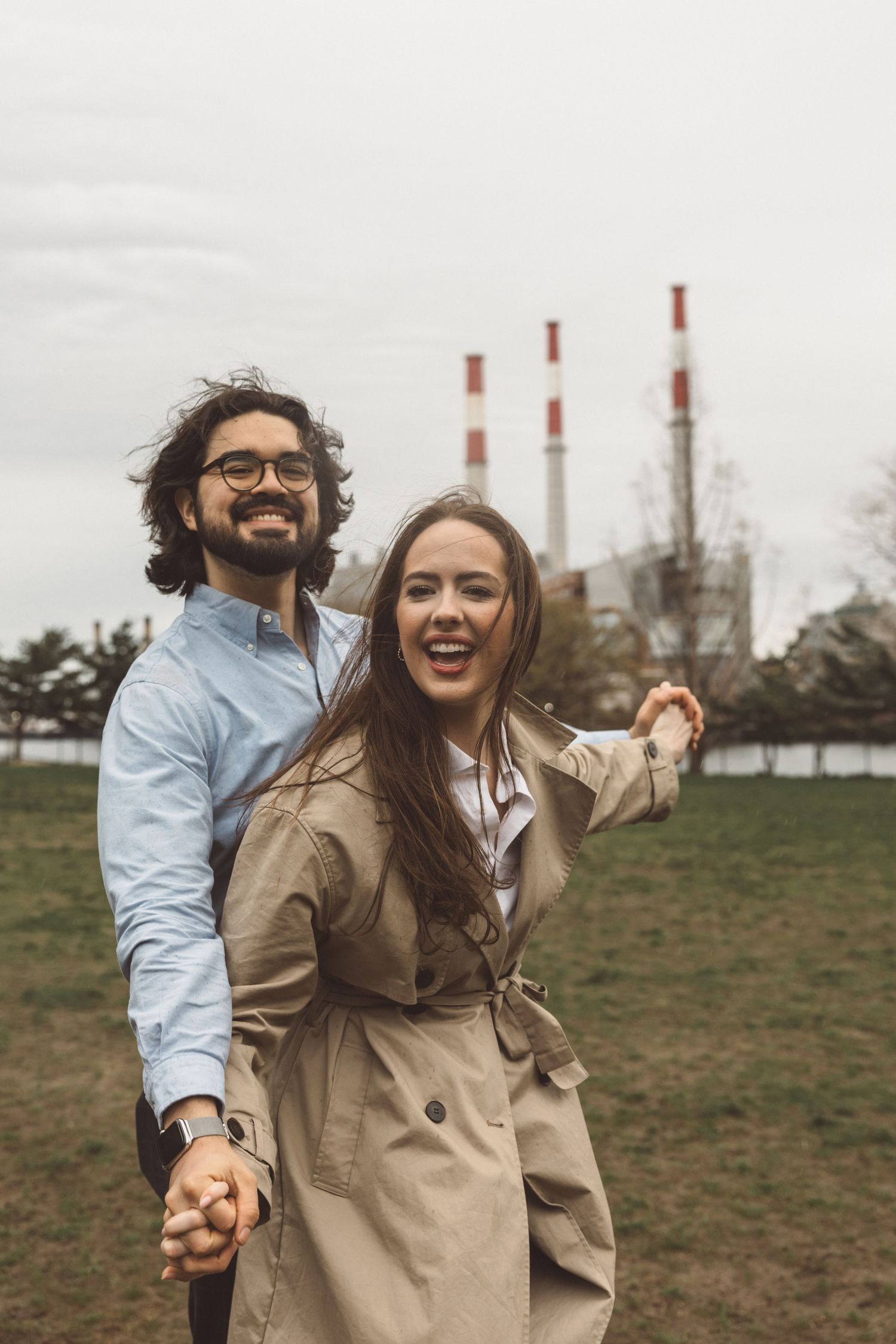 Playful couple frolicking in an open field in Queens, New York at golden hour