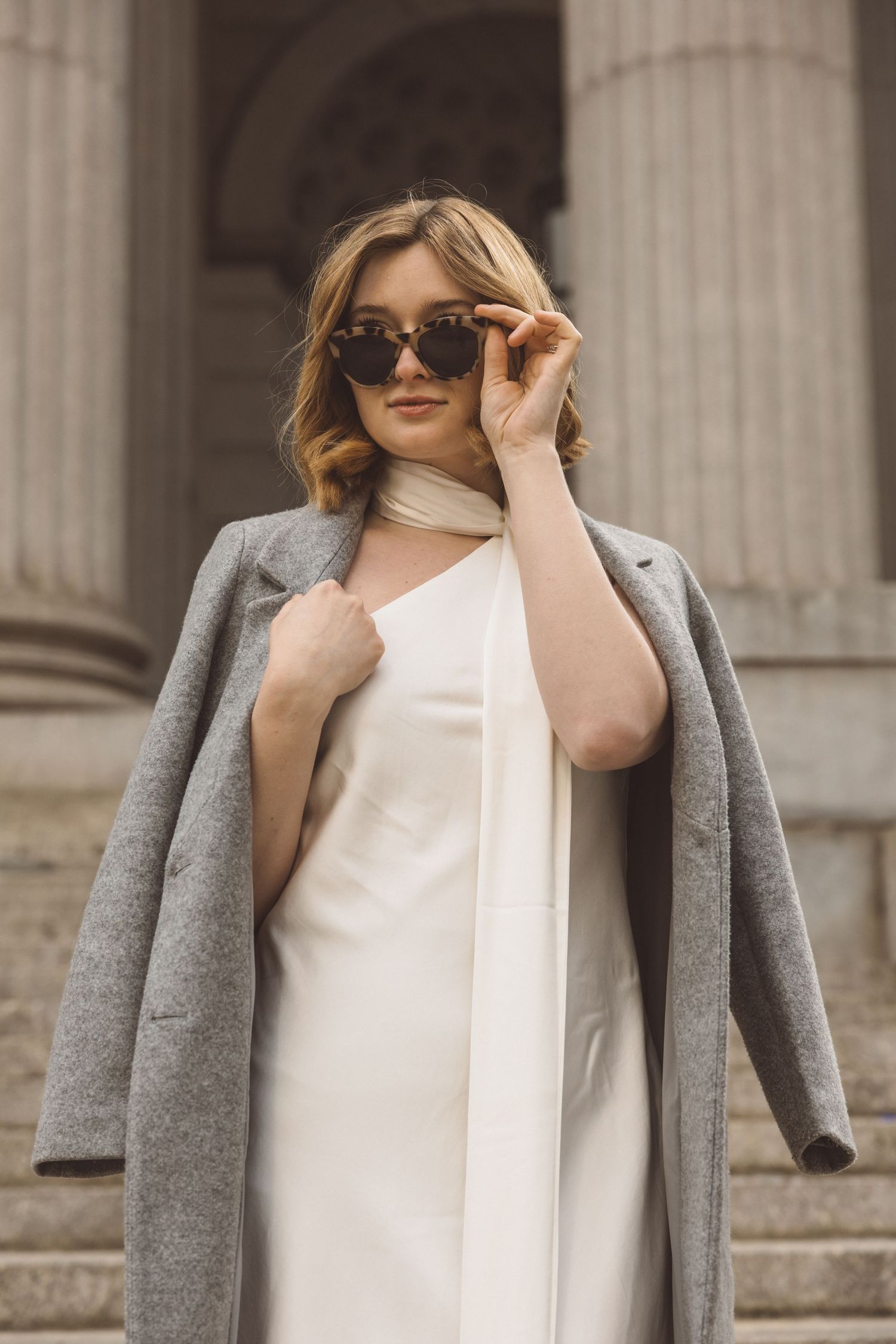 Chic bride celebrating her NYC courthouse wedding on steps of the Marriage Bureau
