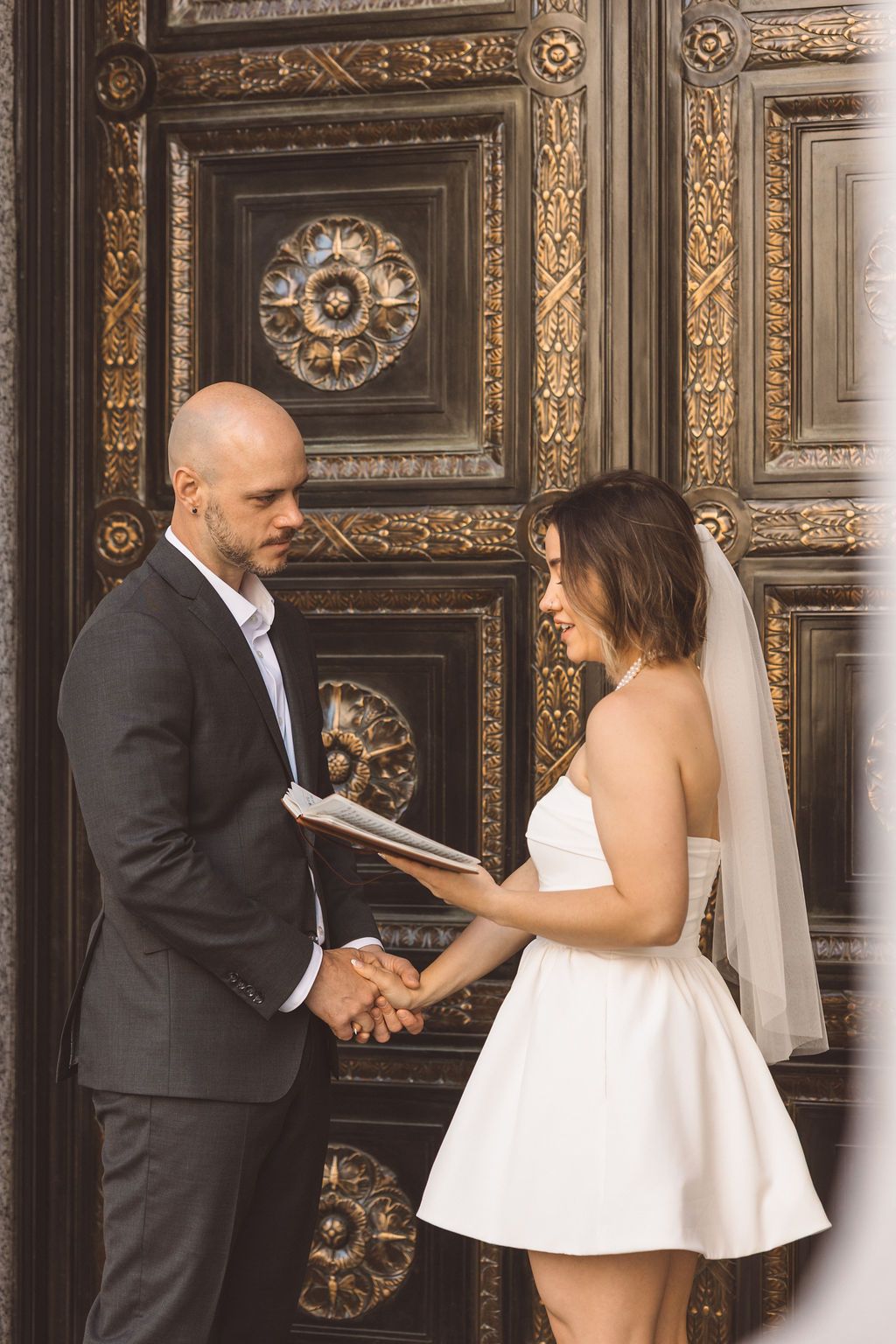 couple holding hands while reading their vows