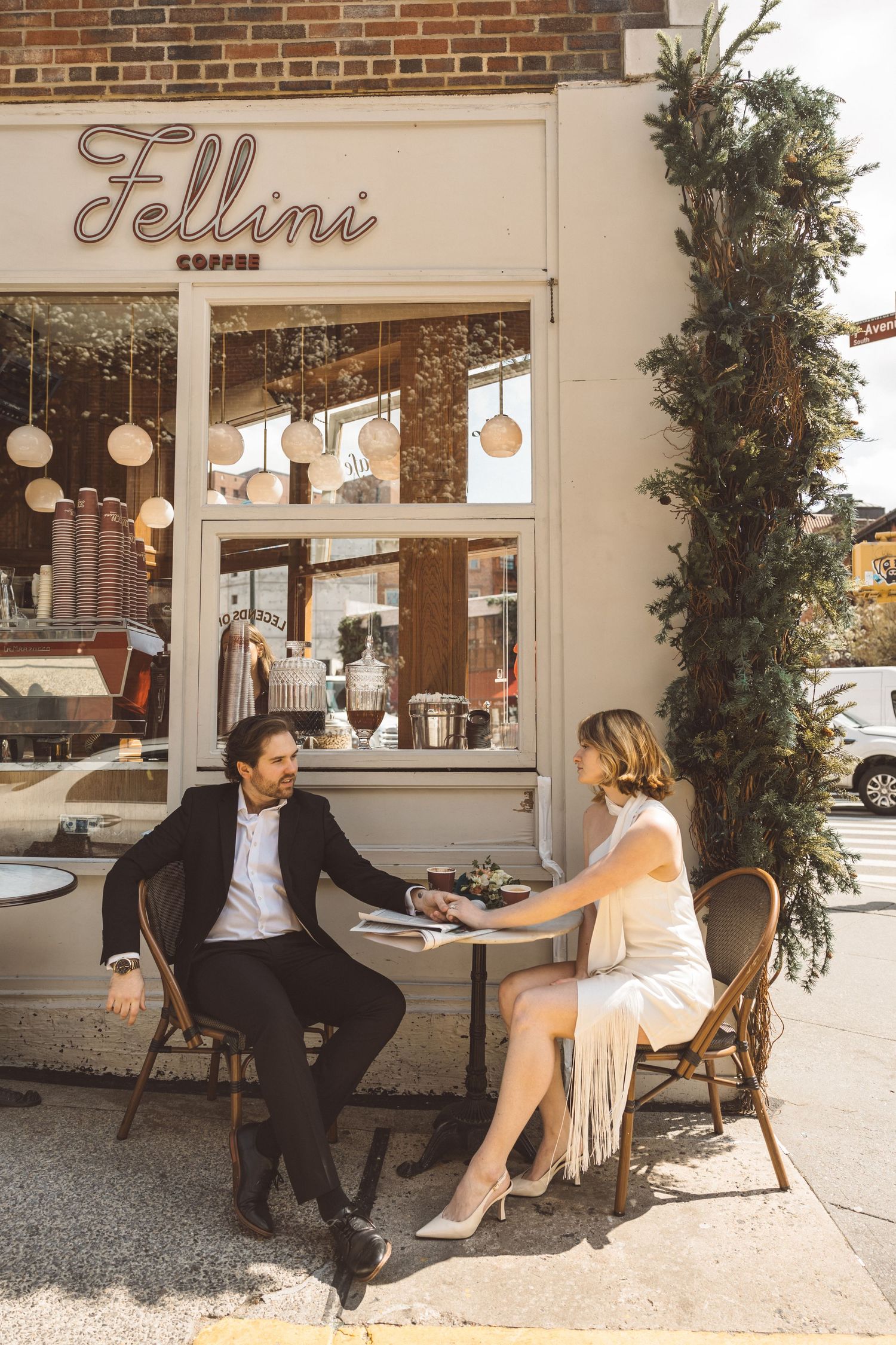 Couple enjoying coffee at European-style café in West Village on their City Hall wedding day