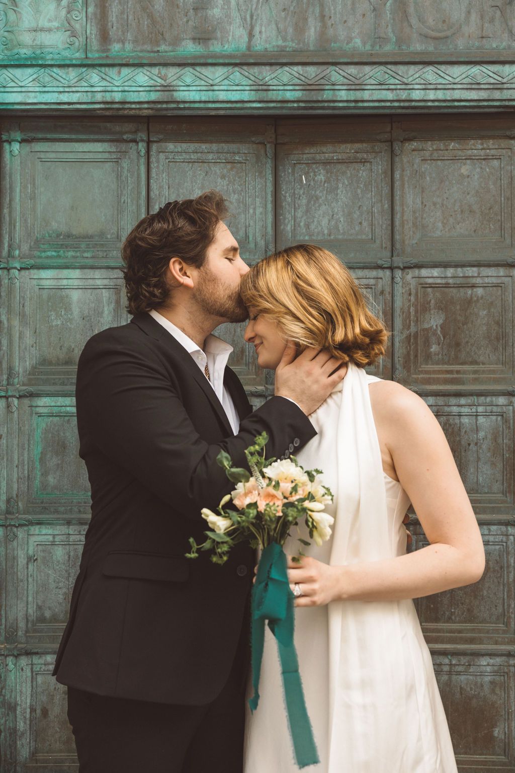 groom kissing the bride on the forehead