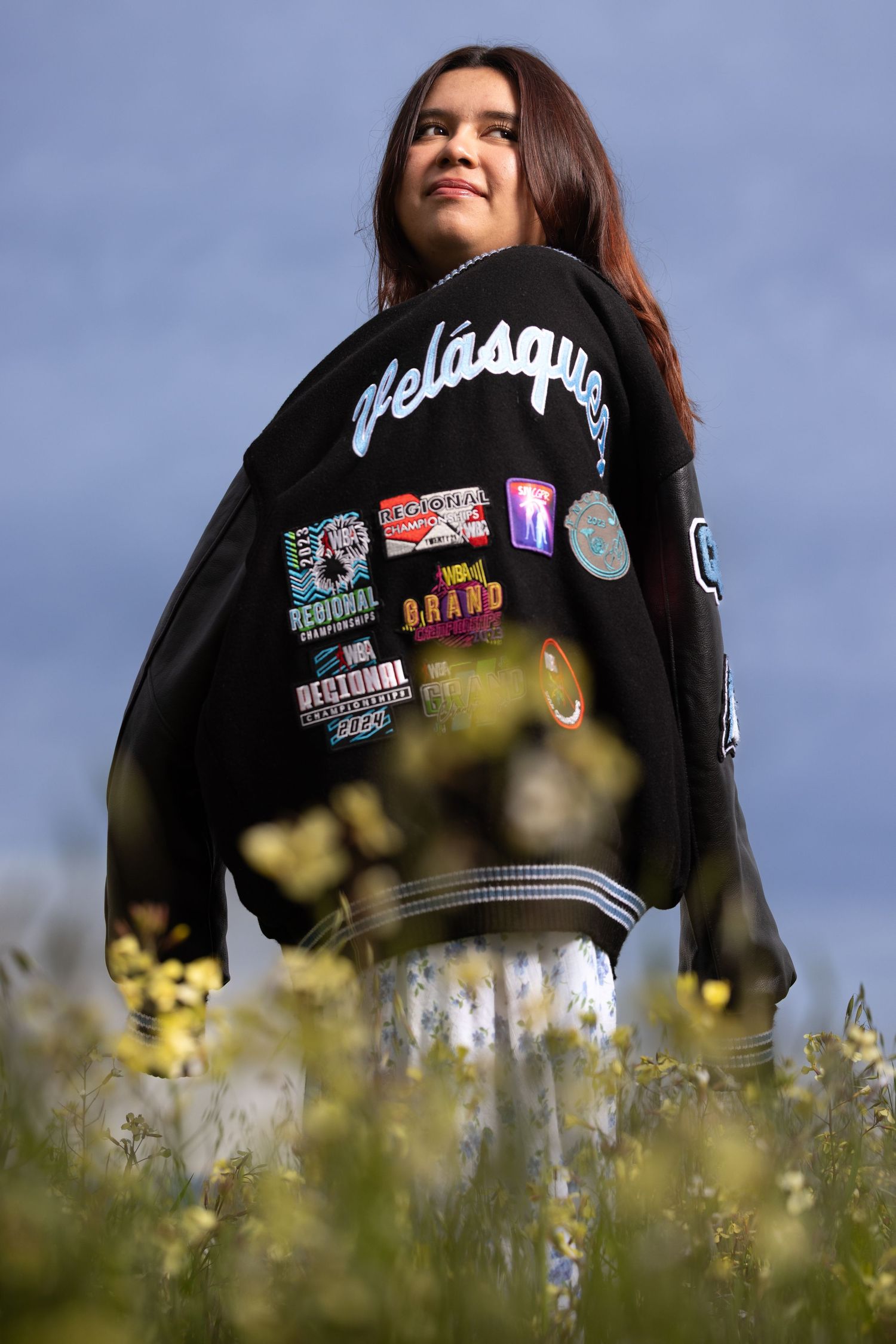 Clovis North High School senior wearing a letterman jacket over her shoulder.