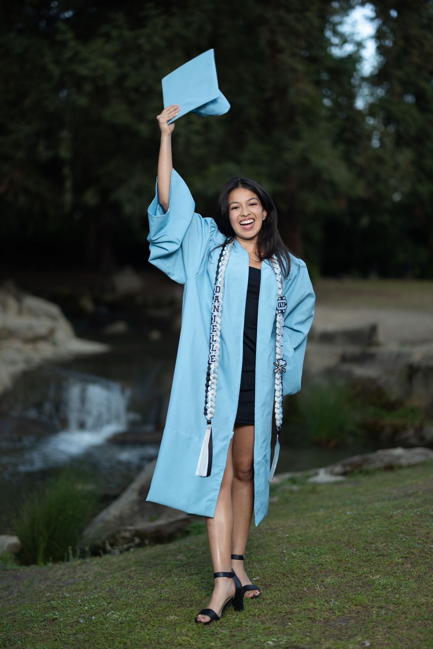 Clovis North High School senior wearing a light blue gown with a light blue cap, at Woodward park in Fresno California.