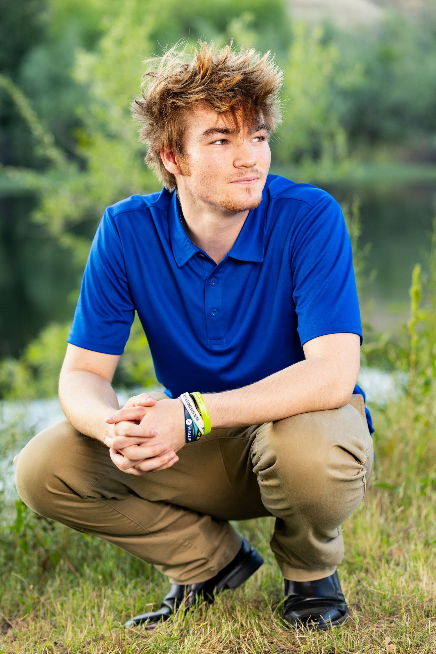 High school senior wearing a blue polo with khaki pants at Lost Lake in Fresno California.