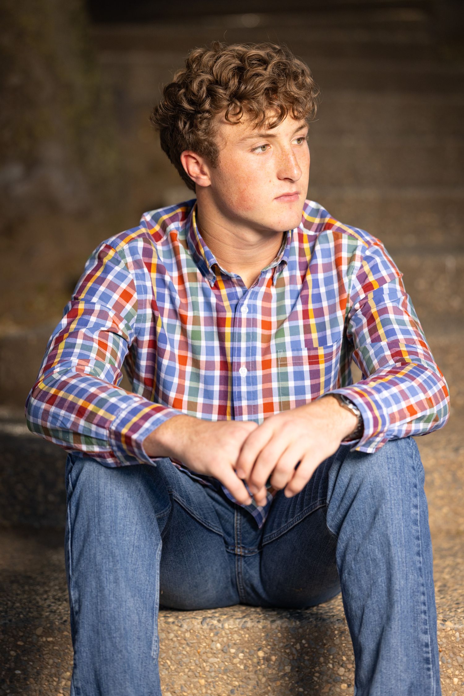 High school senior wearing a checkered shirt and jeans in Clovis California.