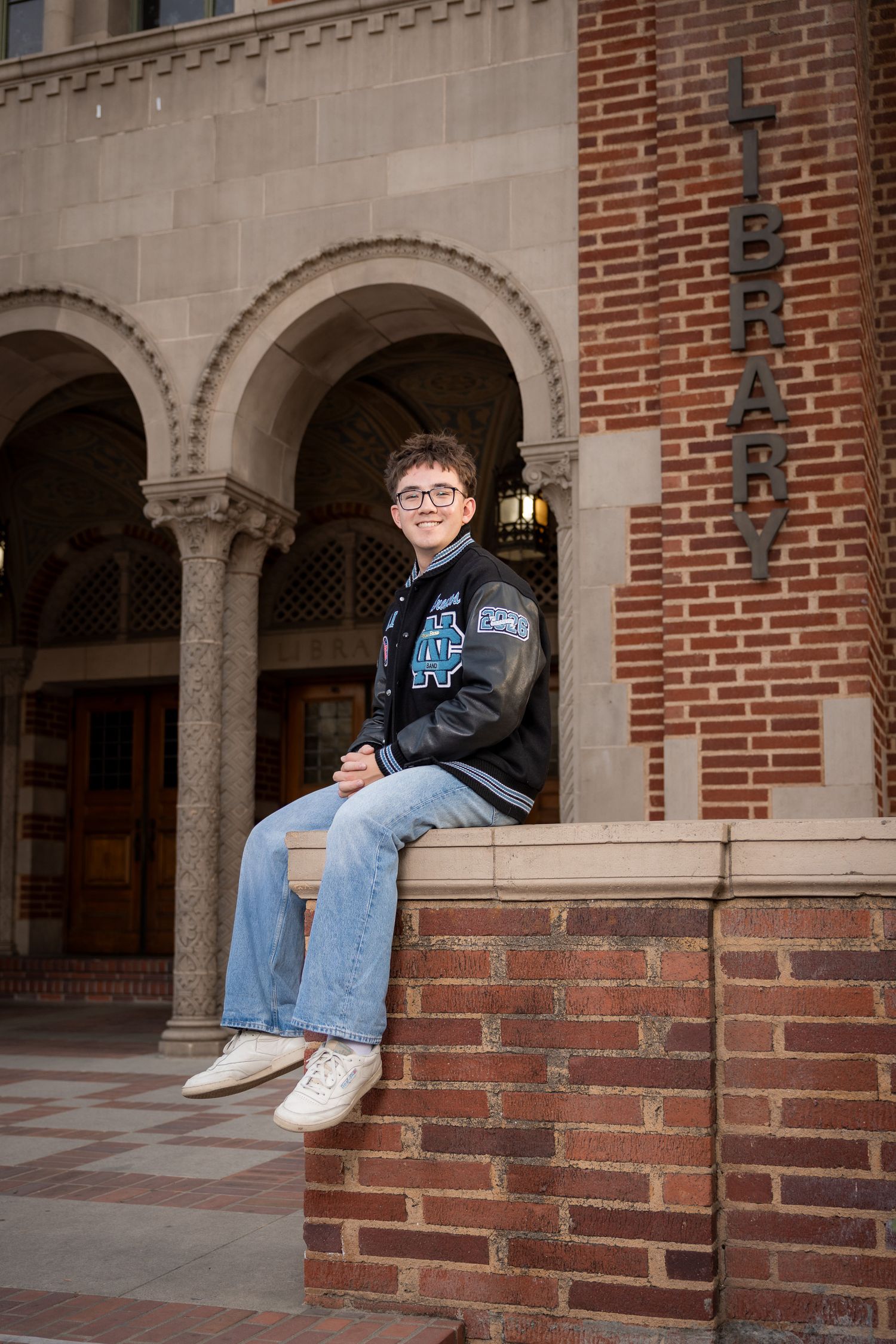 Clovis North High School senior wearing letterman jacket at the library of Fresno City College.