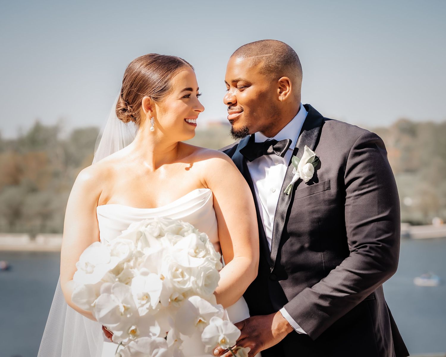 A joyful wedding couple shares an intimate moment by the waterfront.