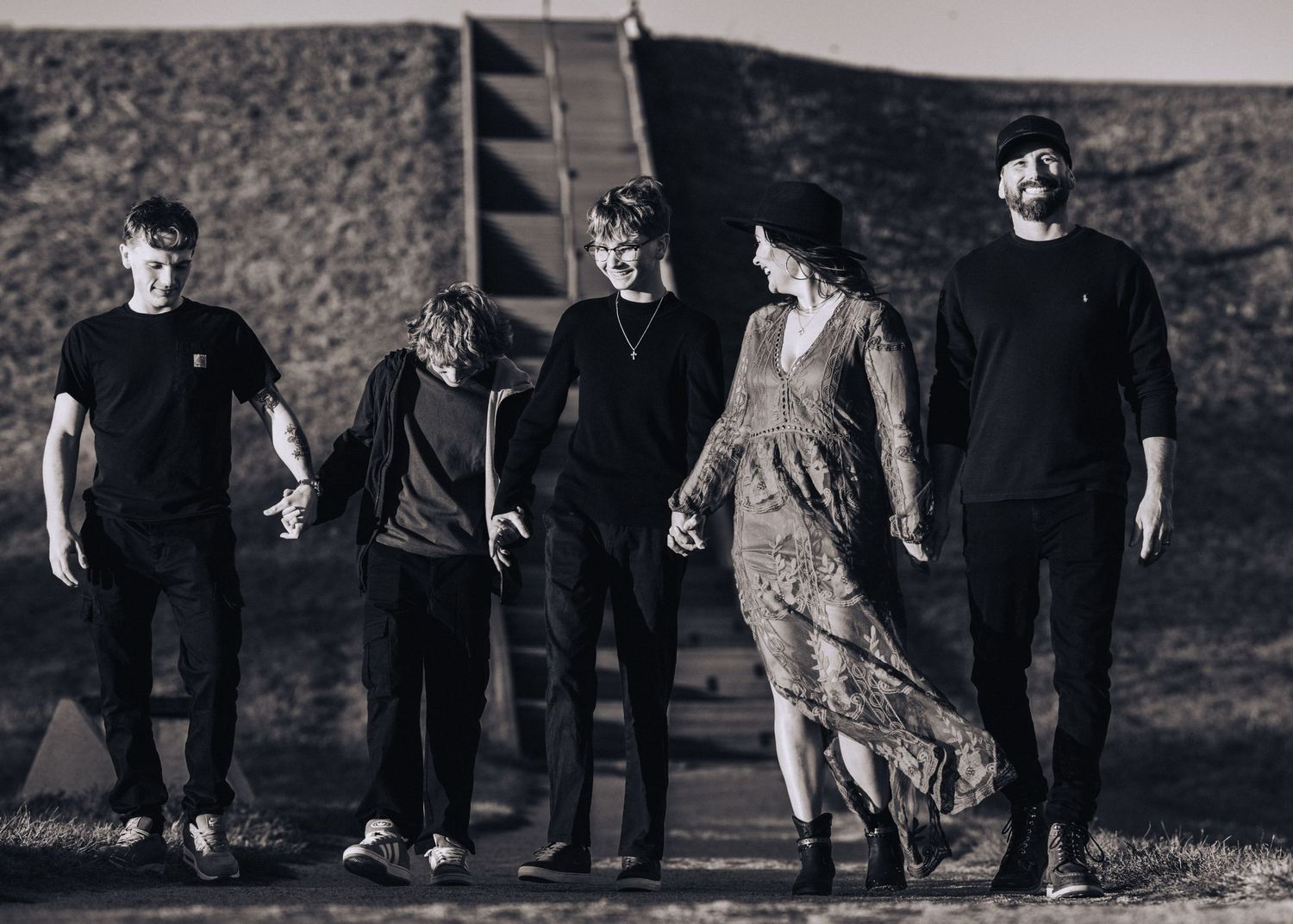 Black and white photo of band members walking together on a path.