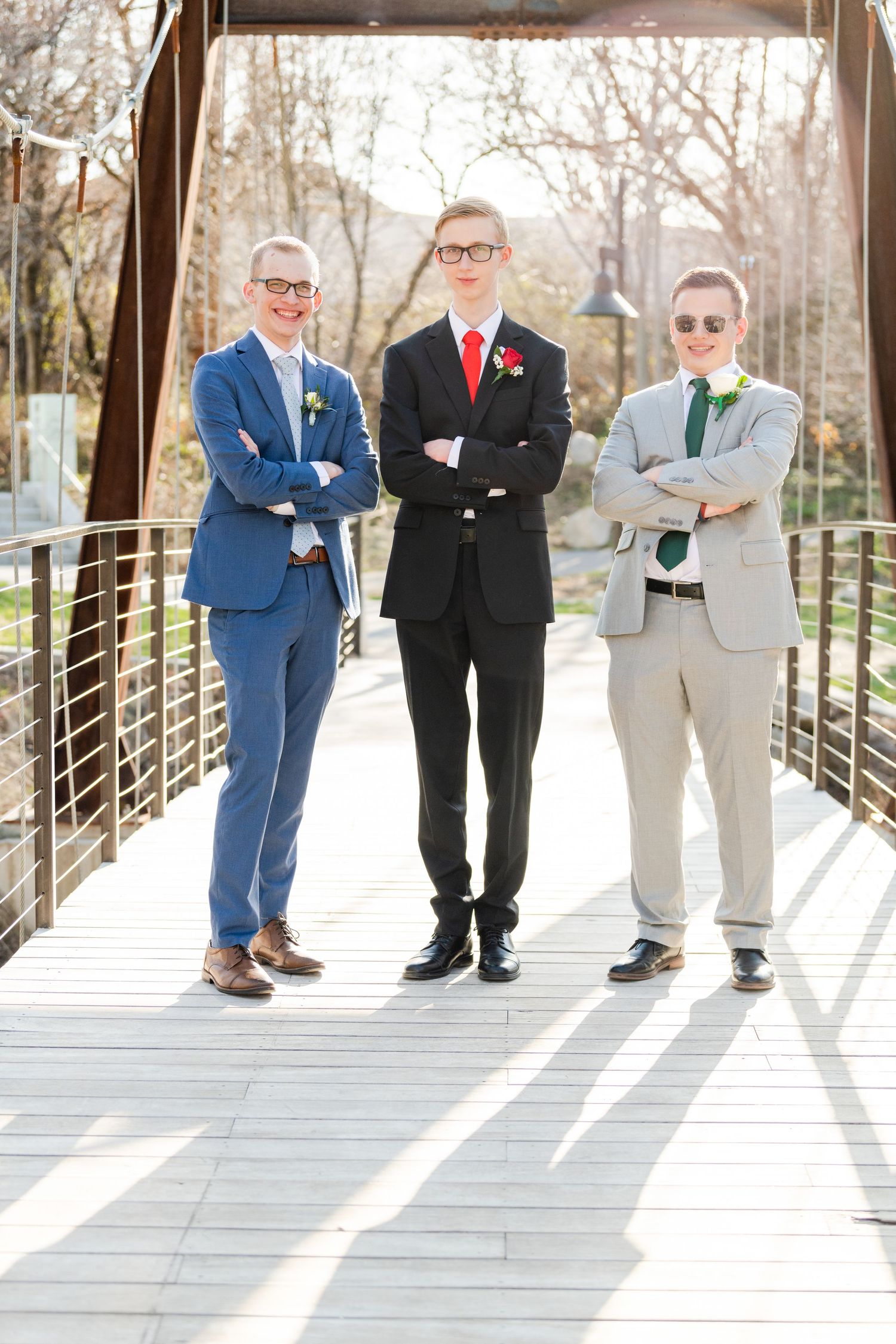 Three boys in suits posing confidently on bridge with strong leading lines for Woods Cross High School prom